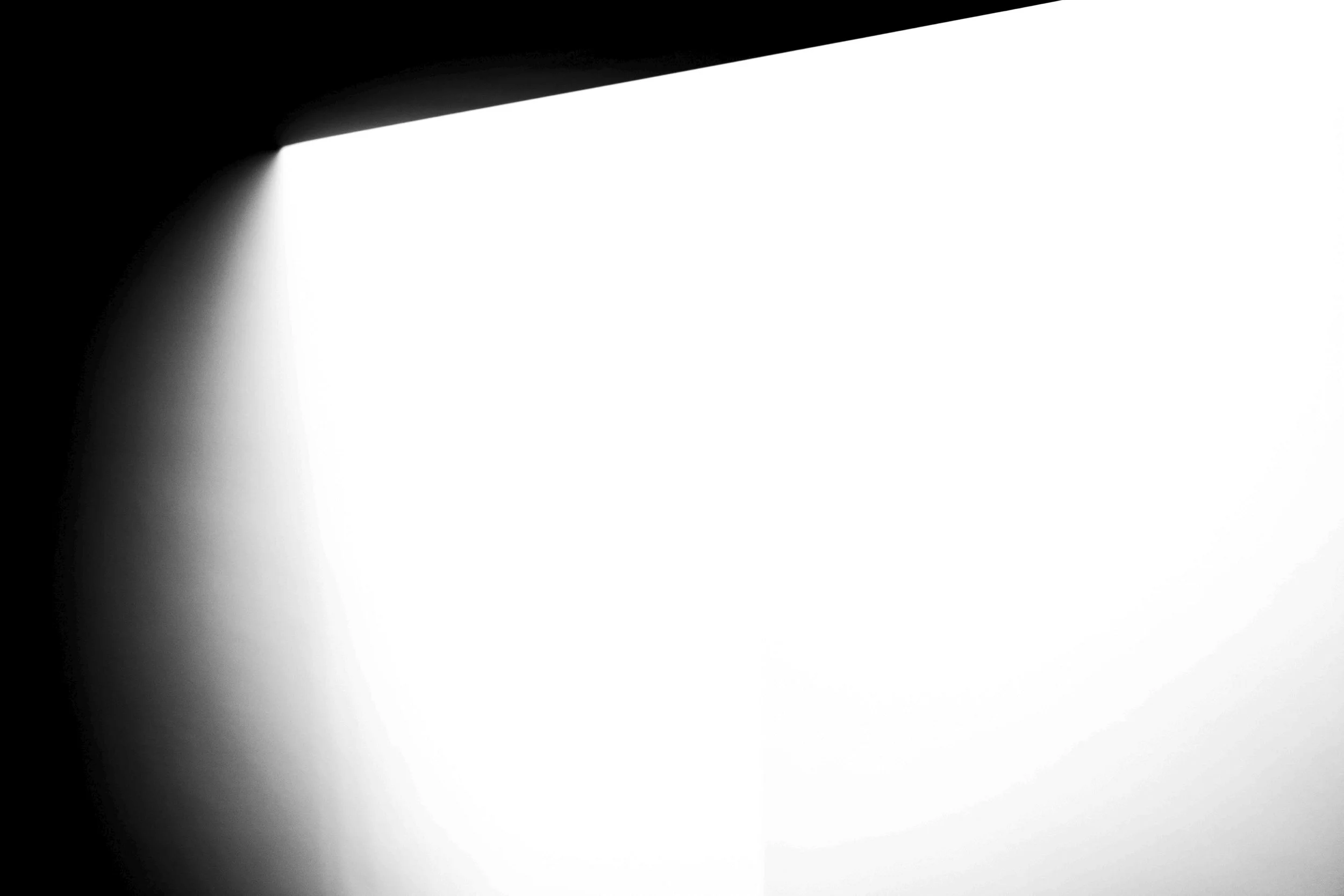 A black and white photograph with a dark background and highlights of light creating a dramatic effect.