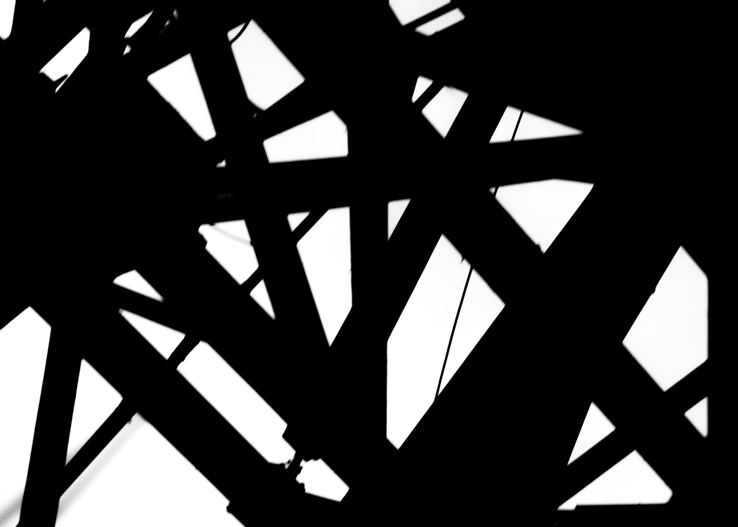 Black abstract geometric silhouette with sharp, angular shapes against a white background