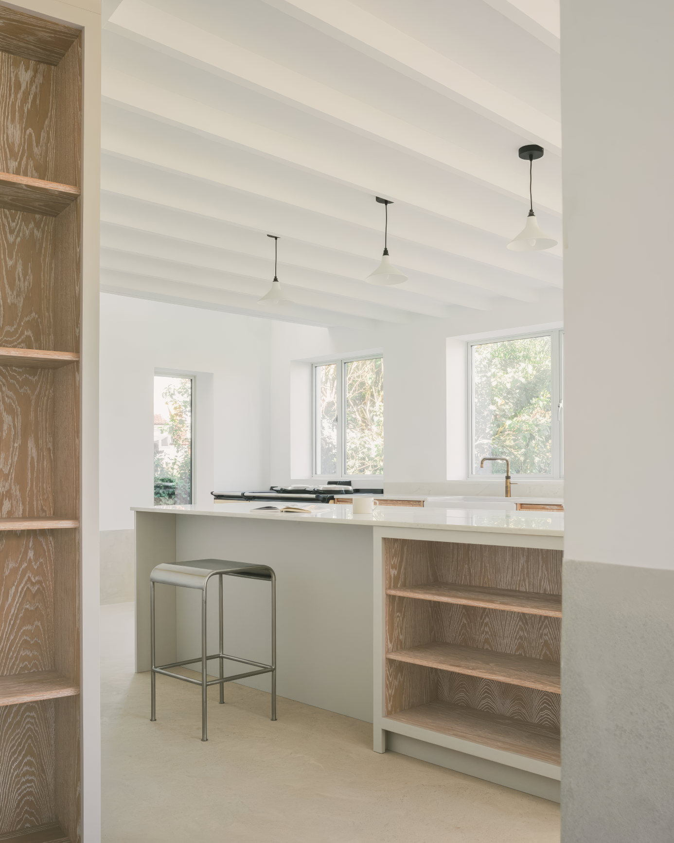 Light-filled kitchen with island, open shelving, and wood accents.