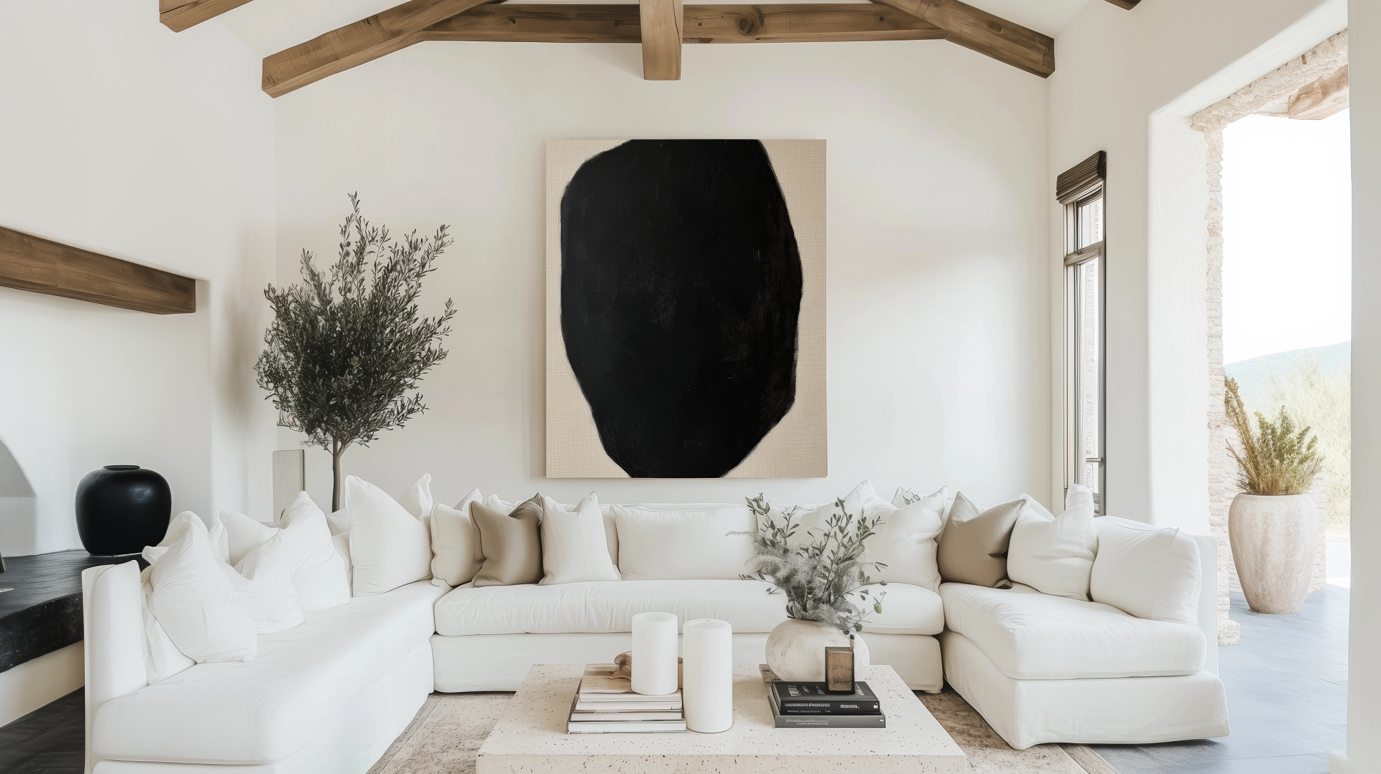 Neutral living room with large abstract black and white art piece above a cozy white sectional sofa, accented by rustic wooden beams and modern decor.