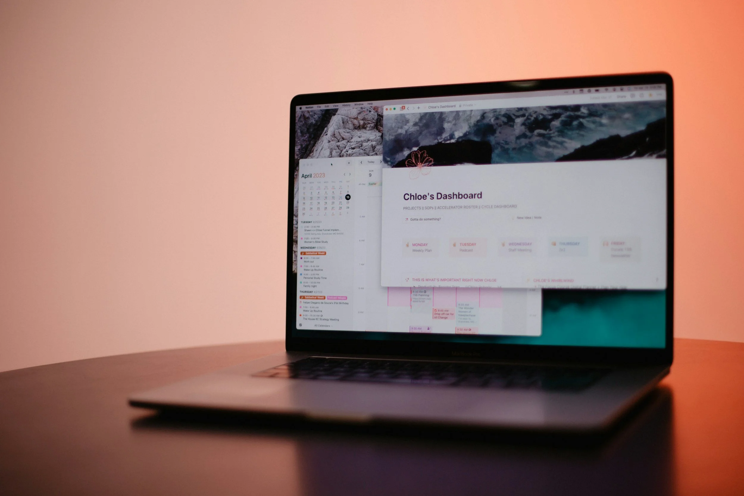 A laptop displaying a digital dashboard on a pinkish background with a calendar, schedule, and project management tools.