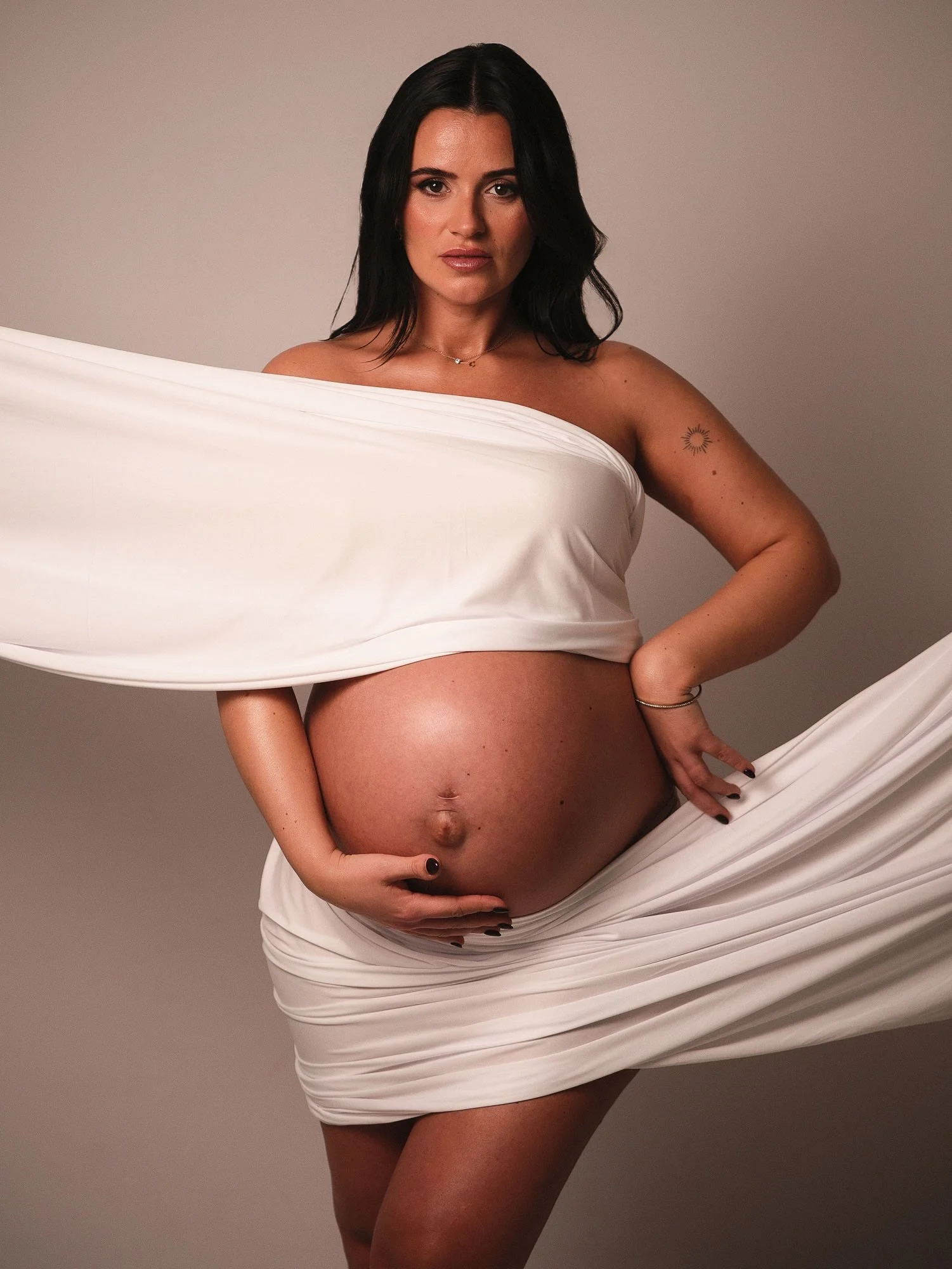 Minimalistisches Maternity-Portrait mit weißem Tuch. Authentisches Schwangerschafts-Shooting im Fotostudio.