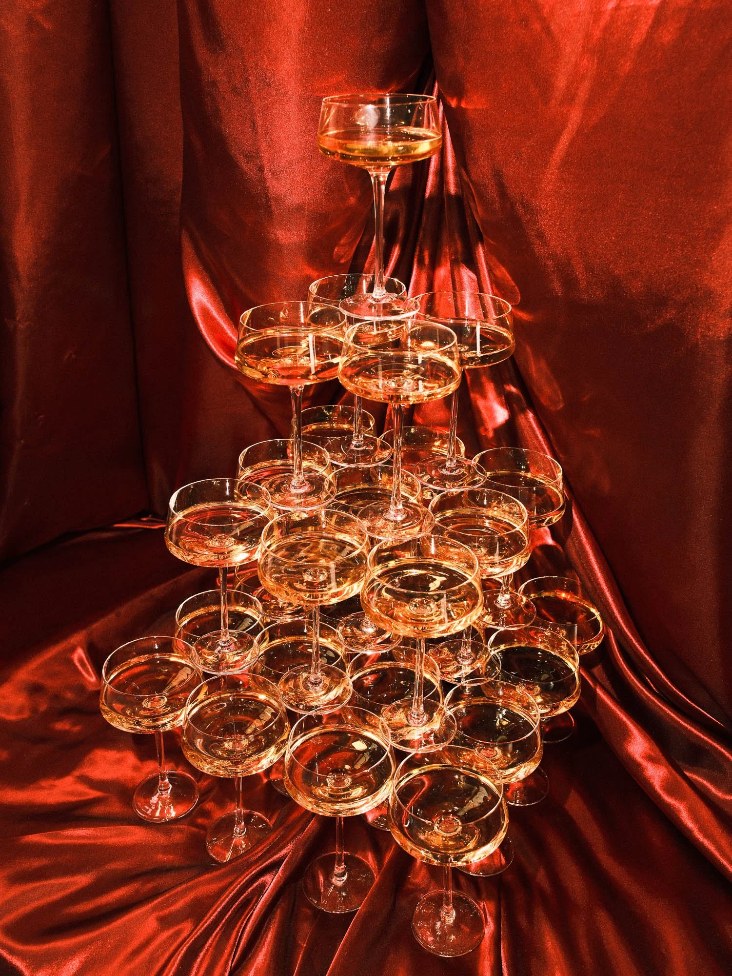 Elegantes Brautpaar befüllt einen Champagner-Turm. Exklusive Hochzeitsfotografie im Editorial-Stil in Frankfurt.