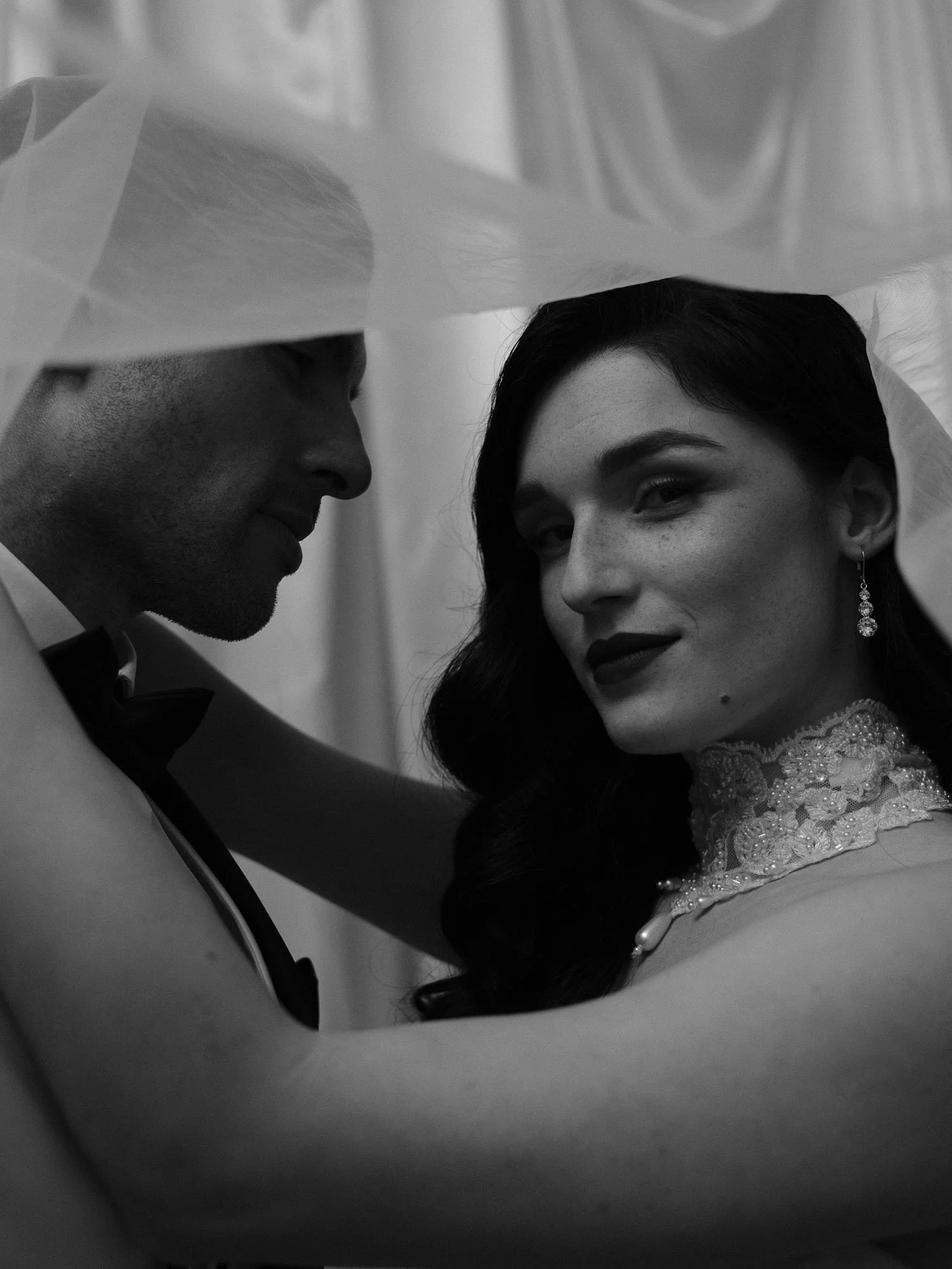 Stimmungsvolles Schwarz-Weiß-Portrait eines eleganten Paares. Reduzierte Hochzeitsfotografie mit Fokus auf Momente.