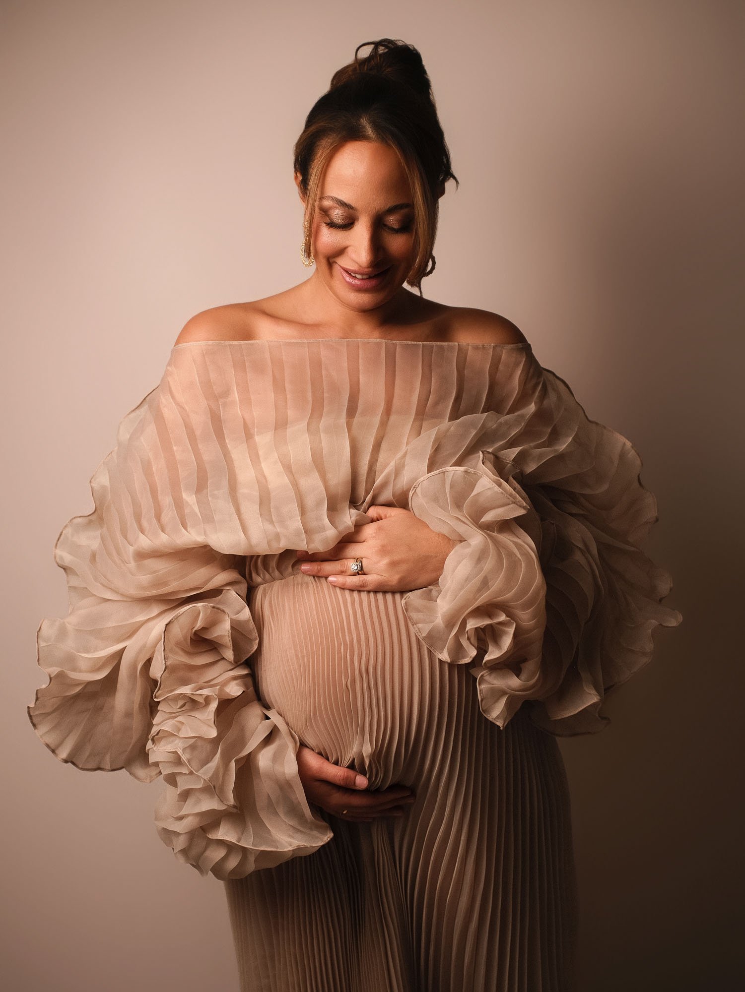 Elegantes Babybauch-Shooting im Plisseekleid. Zeitlose Schwangerschaftsfotografie im Studio.