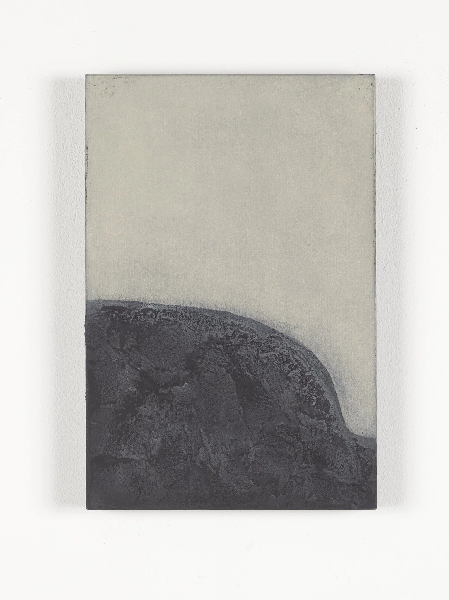 Close-up of a gray granite rock with a smooth, rounded edge, placed on a white background.