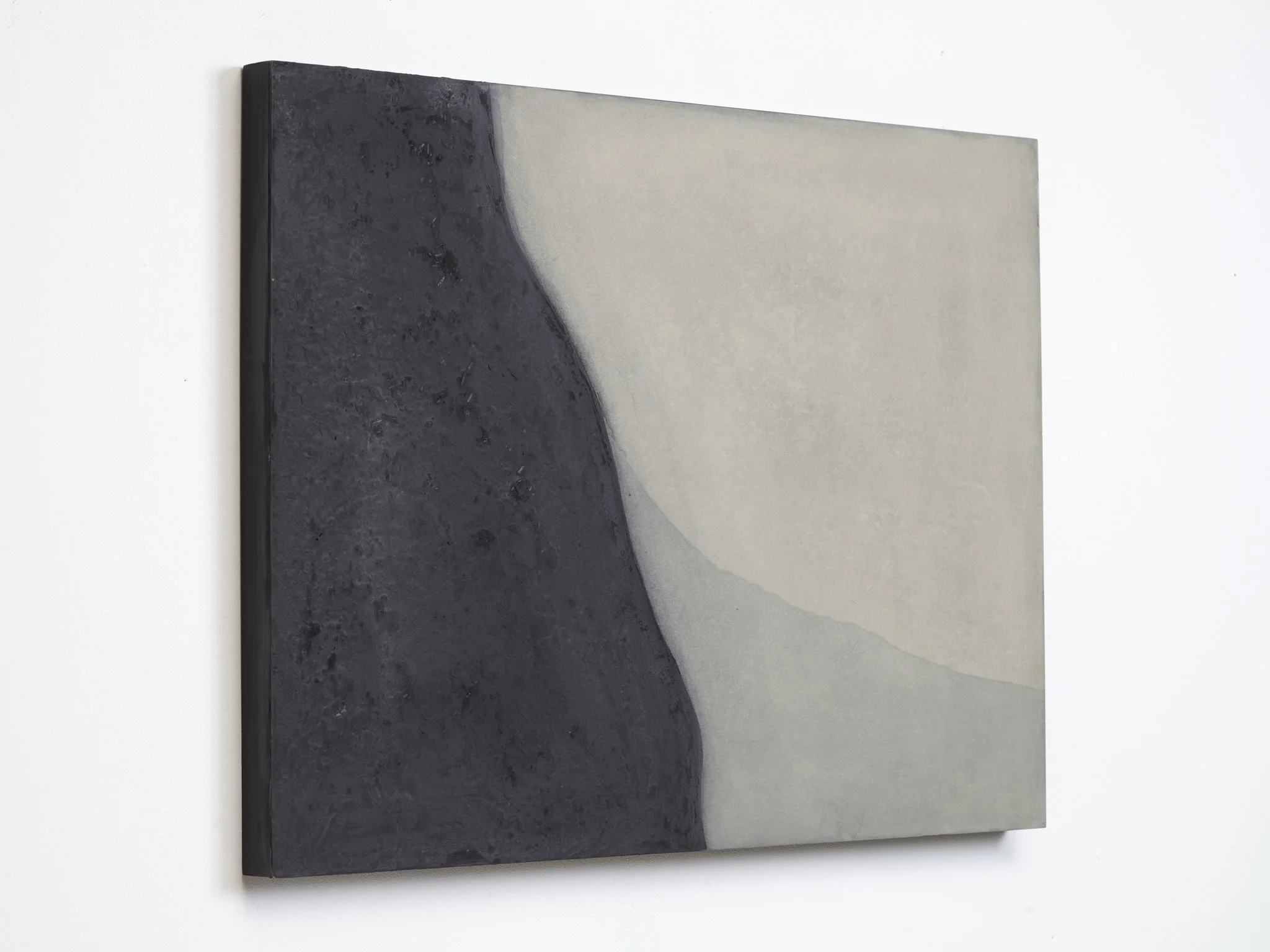 A black and gray hardcover book with a minimalist design, placed on a white surface.