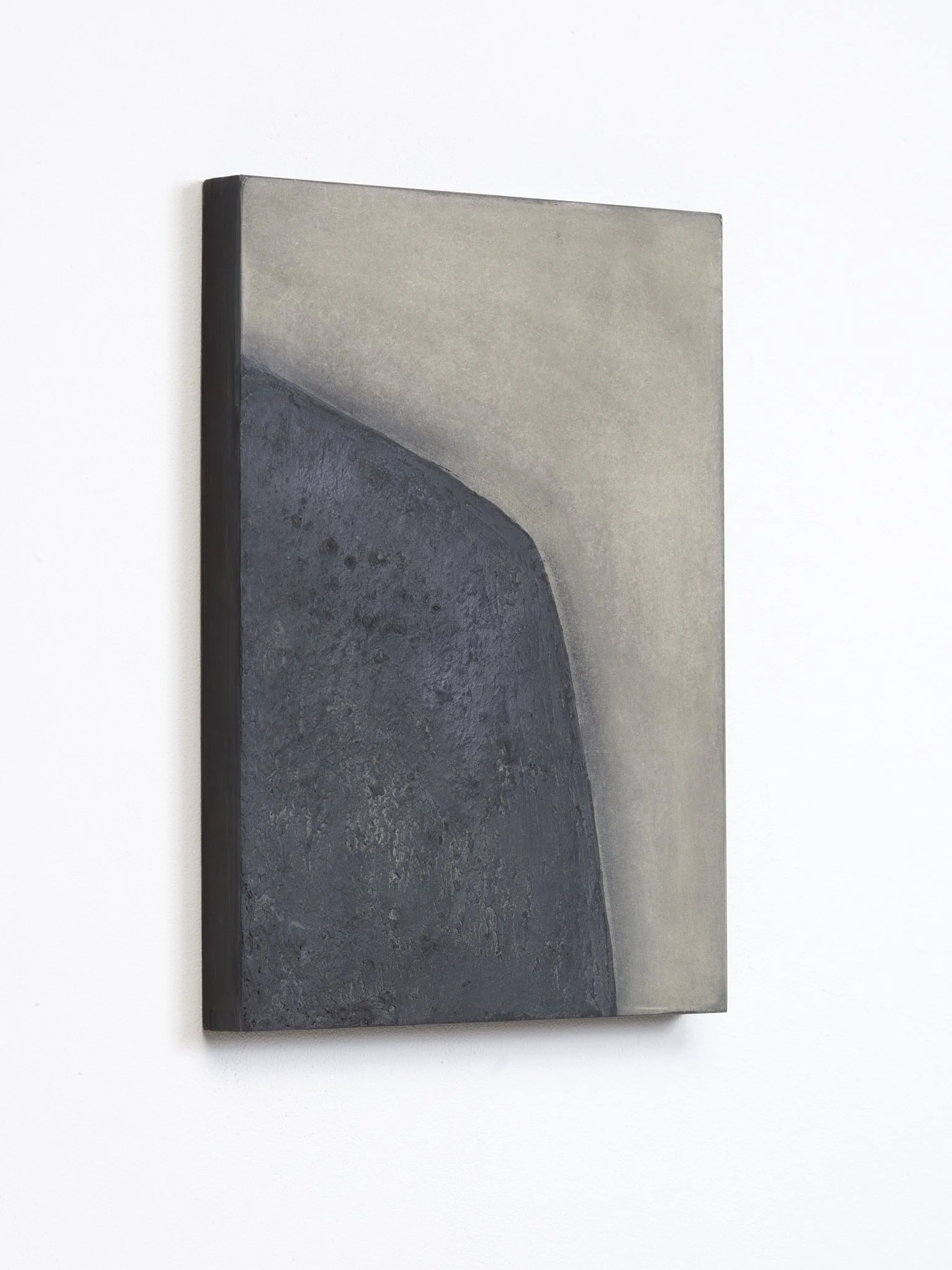 Abstract painting with shades of gray, black, and white, displayed on a wall.