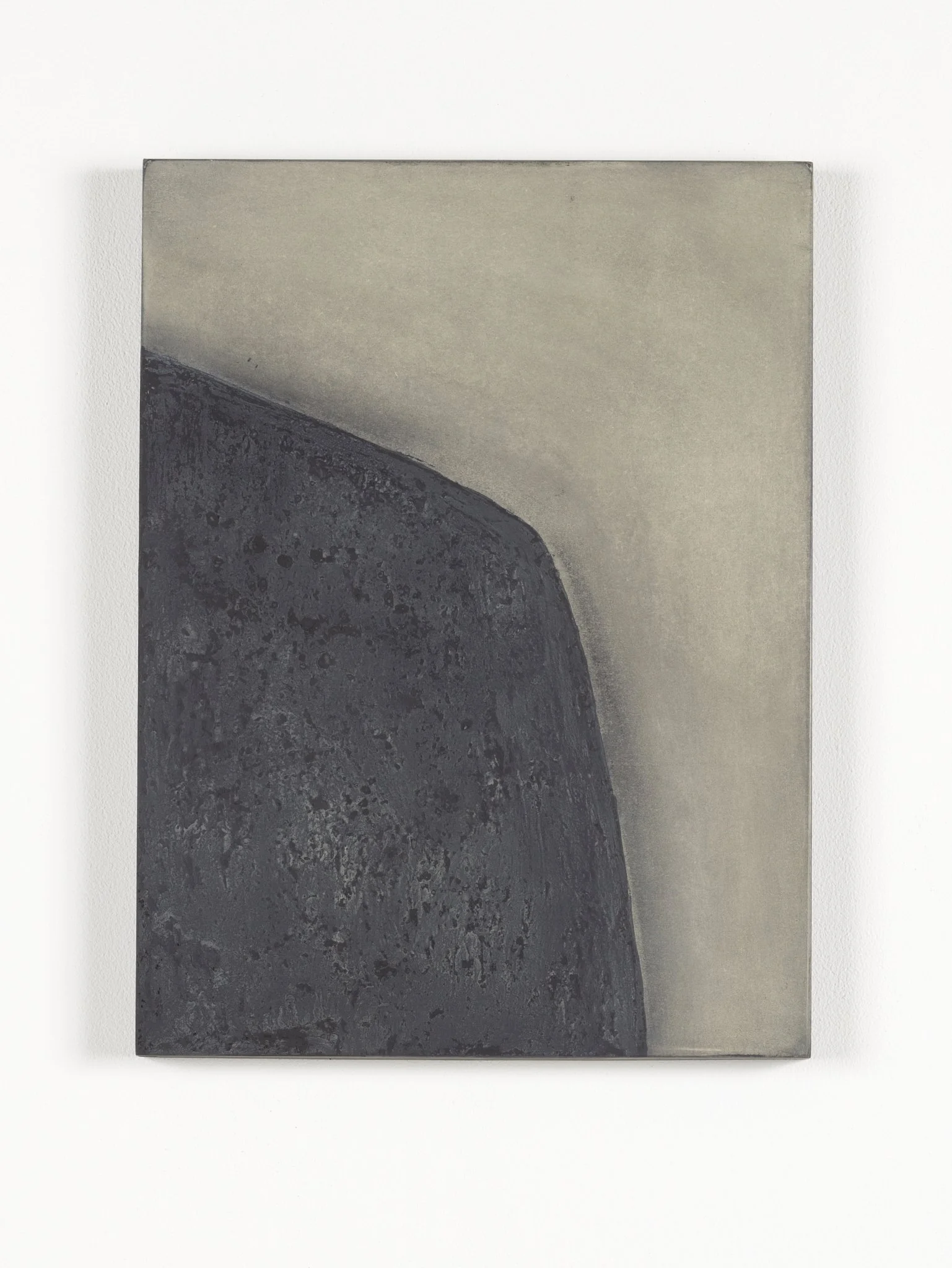 Close-up view of a textured, rectangular piece of artwork or material with a dark, rough surface on the lower left and a smooth, light-colored surface on the upper right, set against a white background.