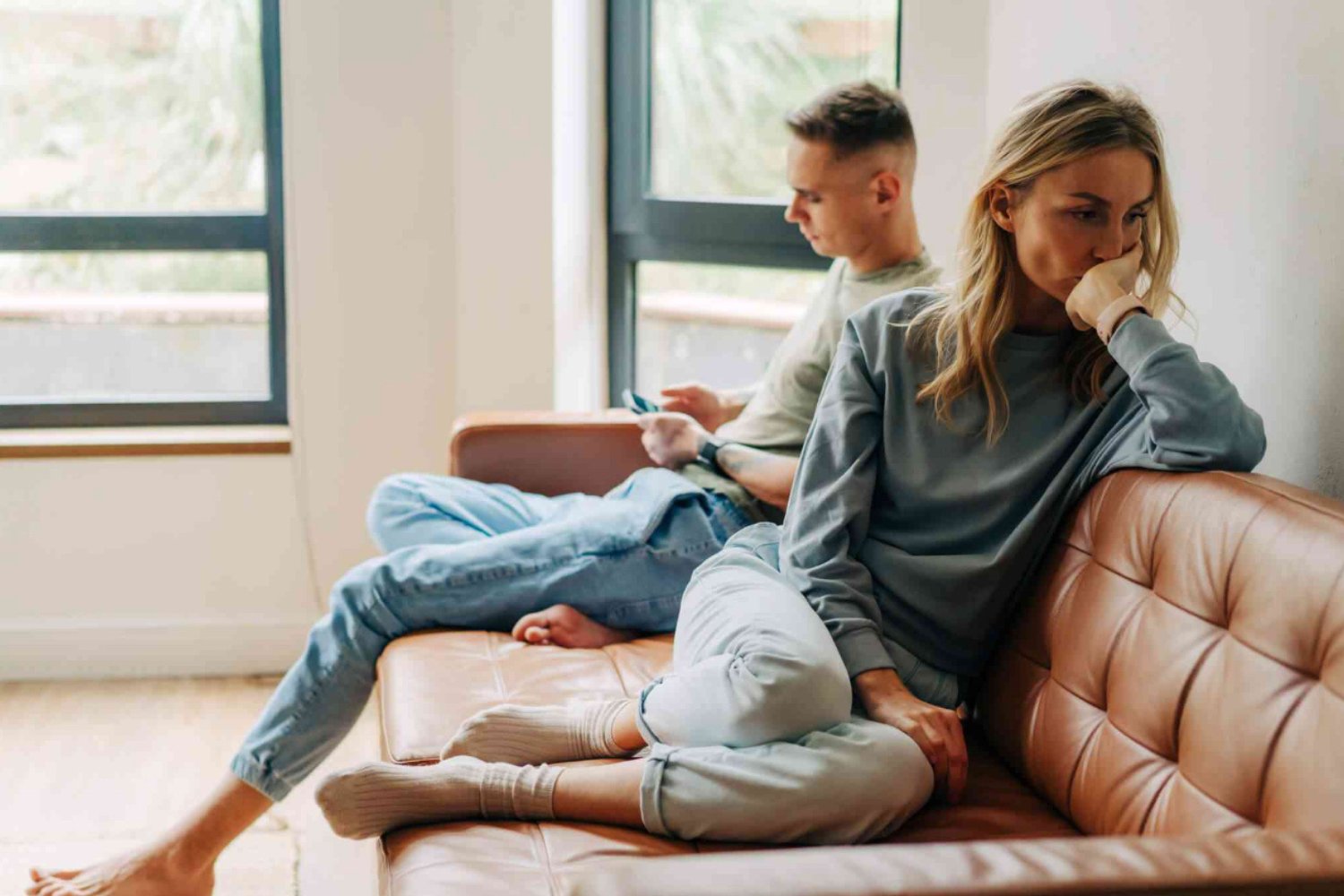 Couple sitting apart in silence after a conversation where they struggled to feel understood