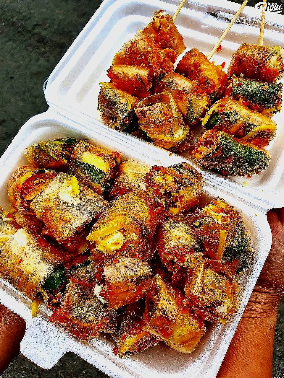 Fried or grilled eggplant and zucchini slices with visible spices, served on a foam container.