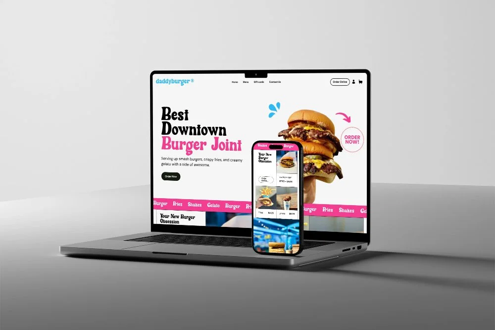 A cross-platform digital display featuring a website for a burger restaurant called DaddyBurger, with a large image of three stacked burgers, and a mobile phone showing the same website's menu.