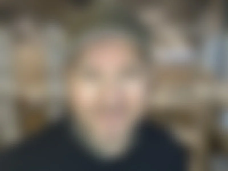 Uklart bilde av et smilende ansikt.