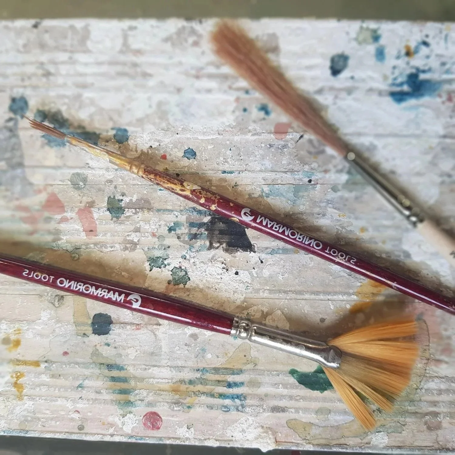 artist brushes on side with paint splashed surface