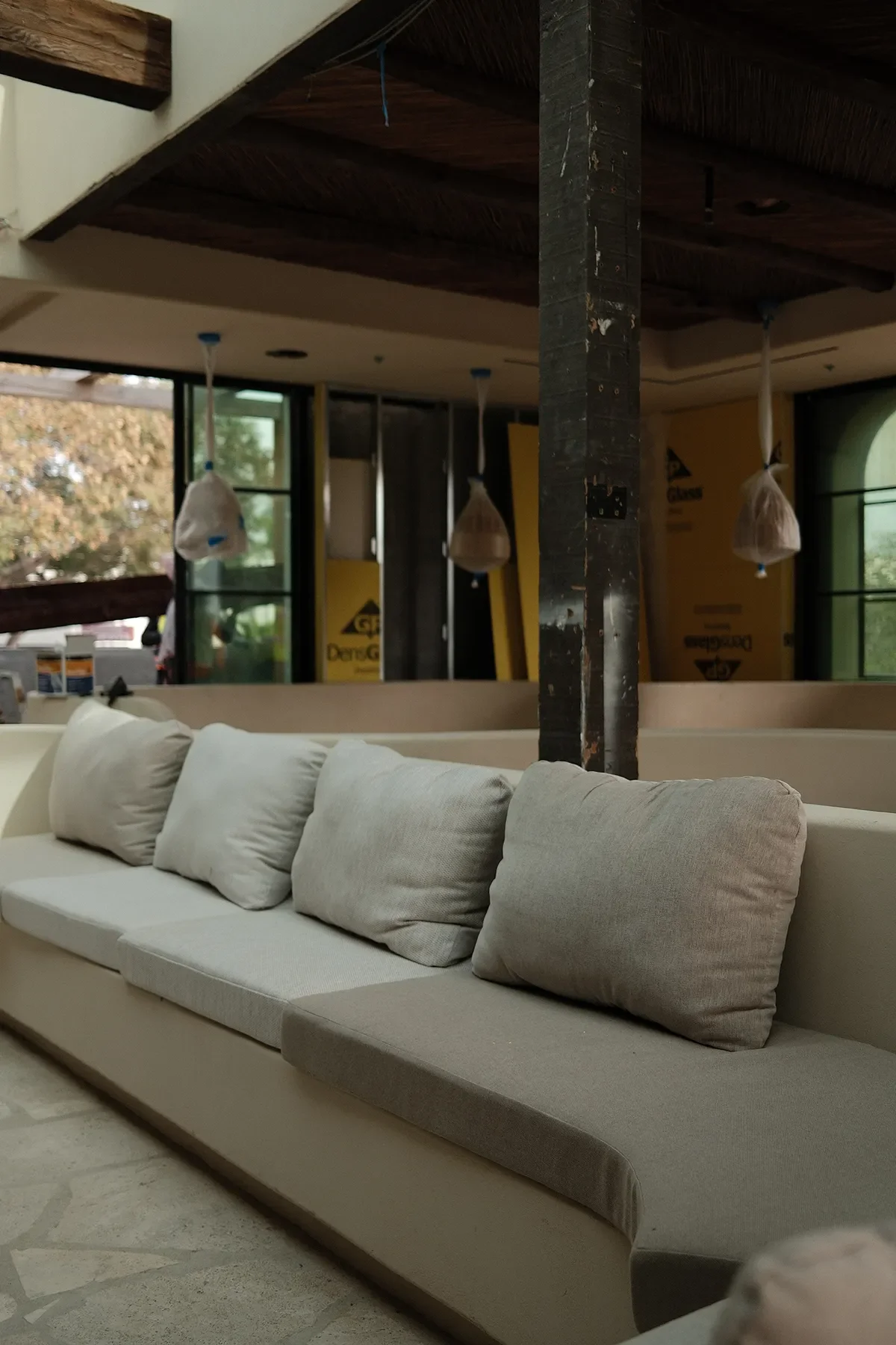 First fit and color selection of the banquette cushions at By The Sea, pendant fixtures still bagged overhead