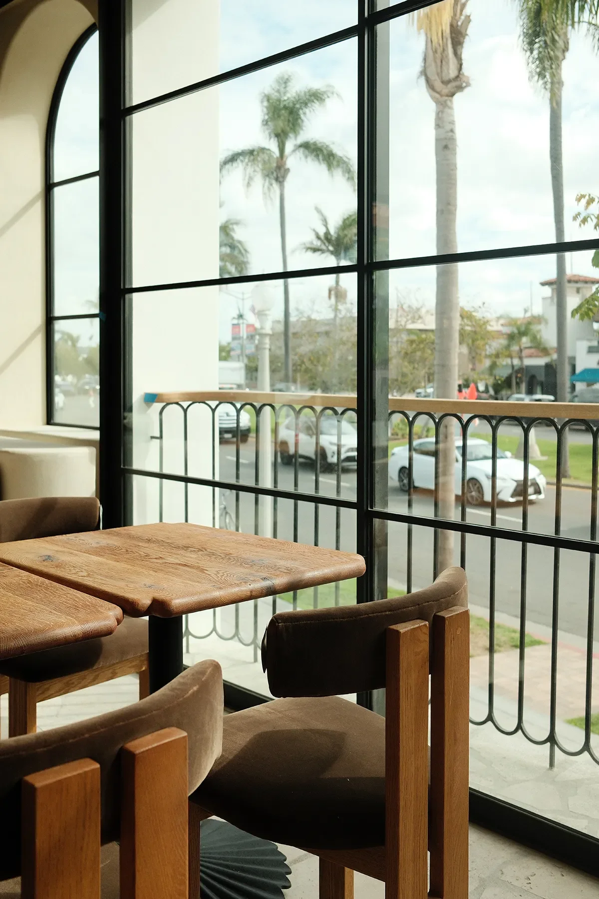 Velvet armchairs and cerused oak tables at the window overlooking Orange Avenue at By The Sea