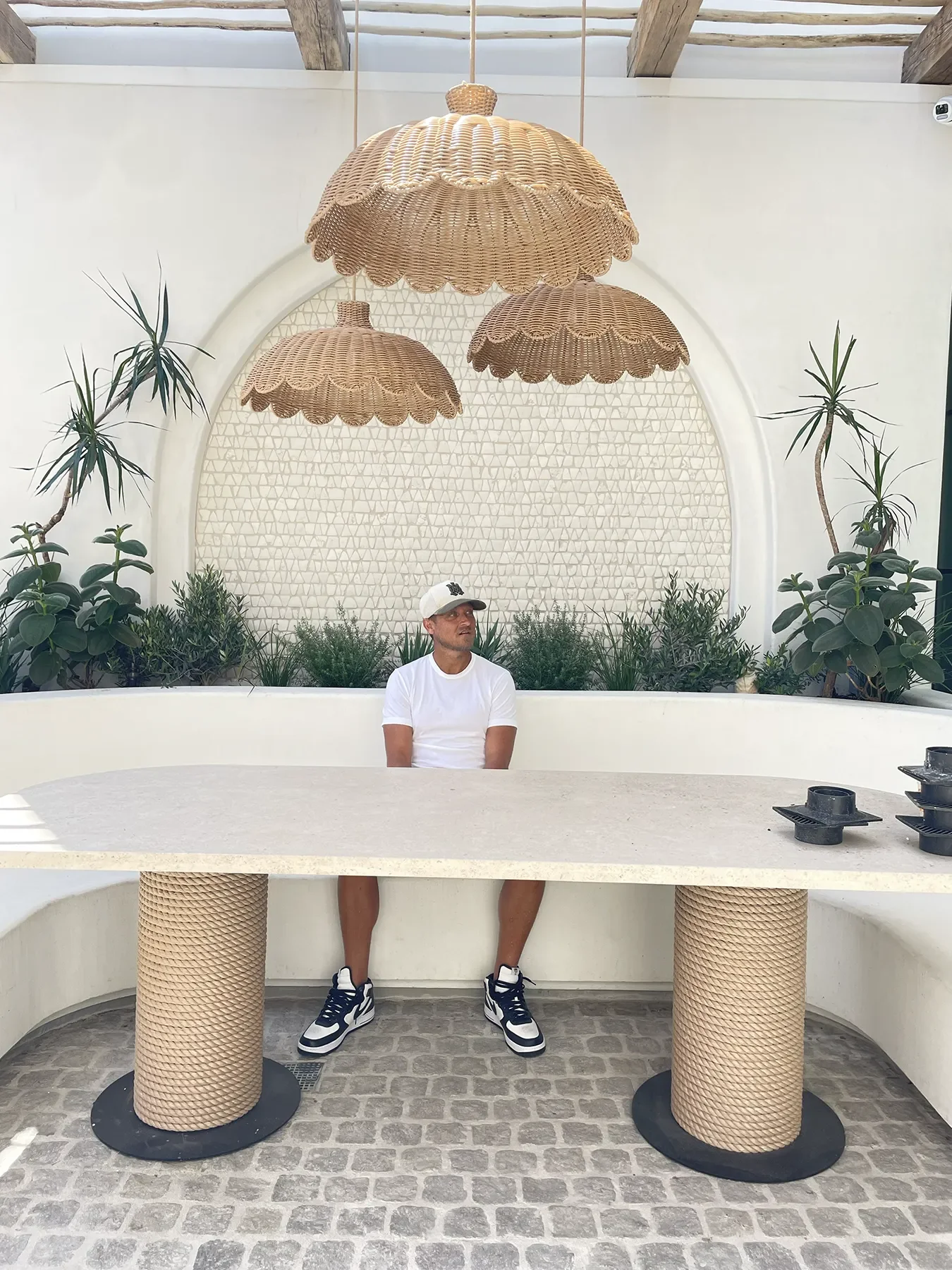 Finished patio nook at By The Sea with scalloped rattan pendants and the arched mosaic tile panel