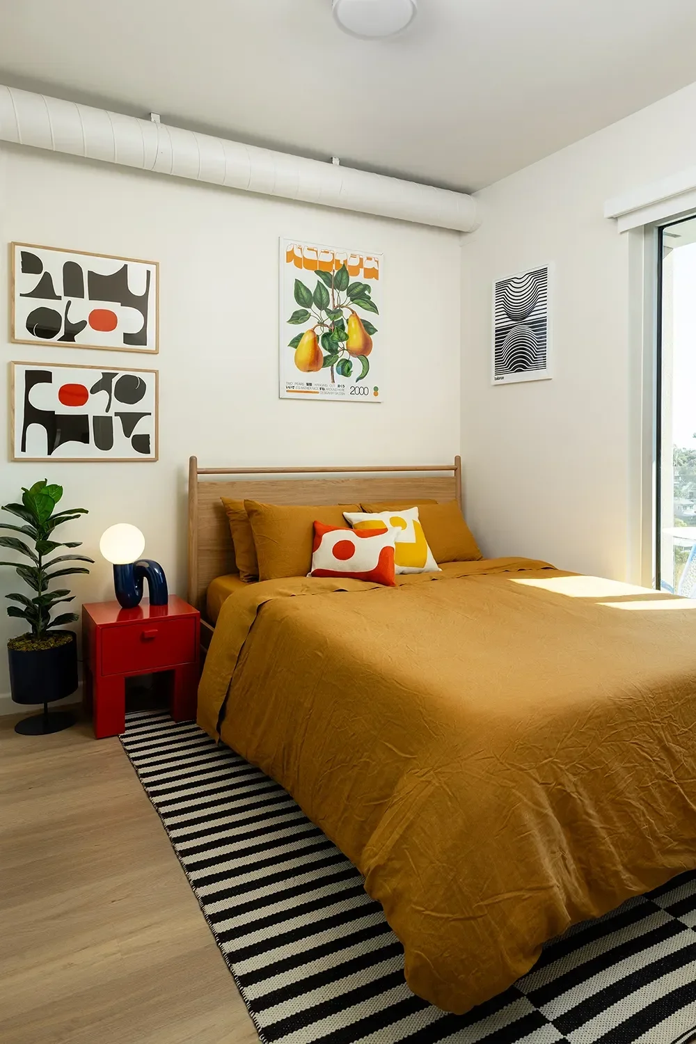 8th-and-u-model-bedroom-ochre-bedding-gallery-wall.webp