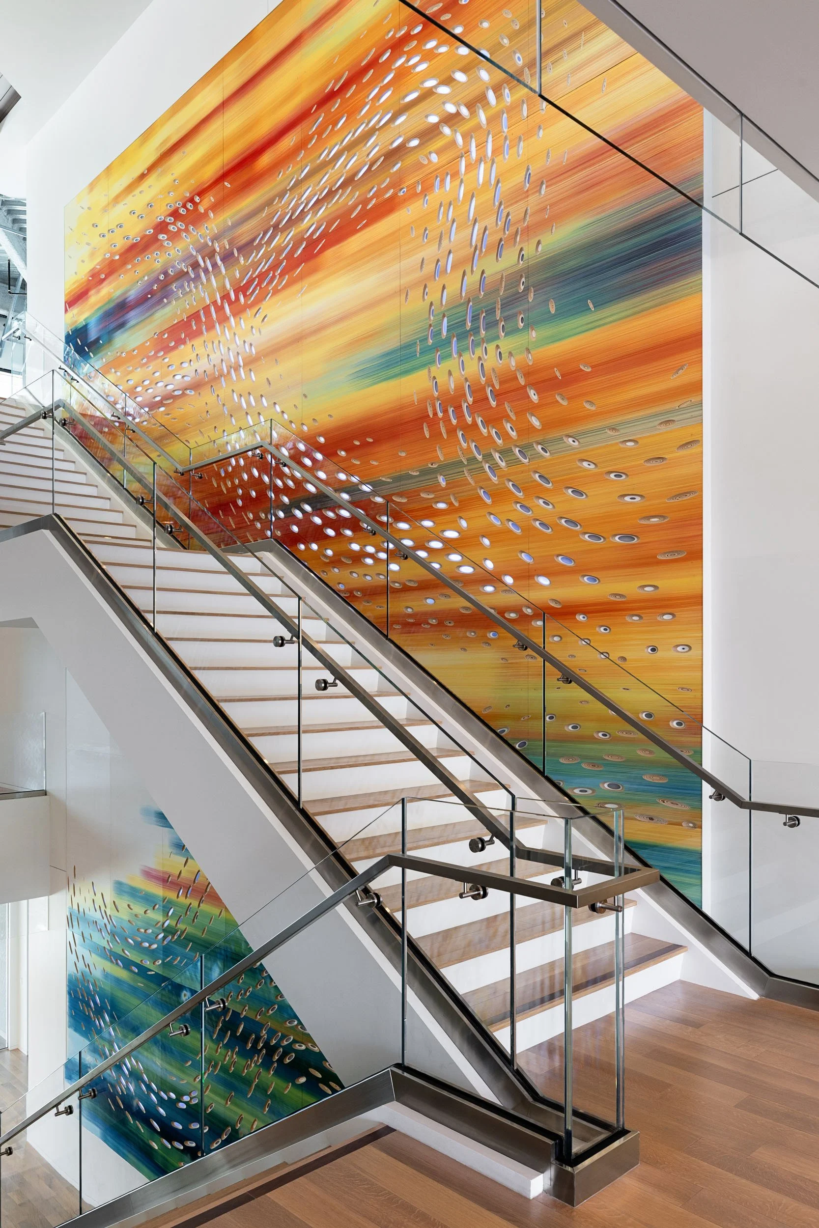 Colorful hand painted art installation stretching across a stairwell, bringing movement and color into the space.