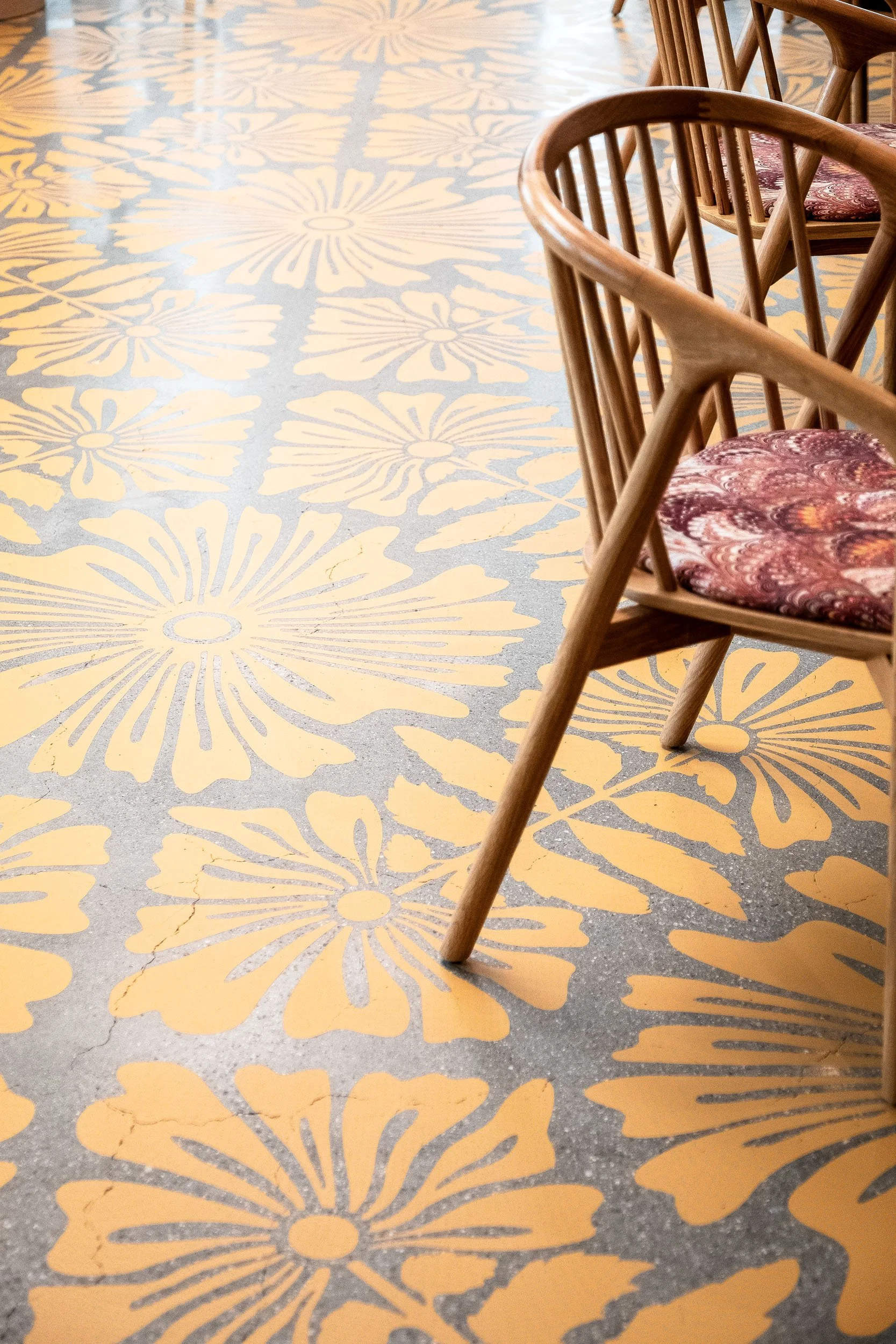 Detailed yellow botanical floor pattern applied to a concrete floor in an office space in Los Angeles.