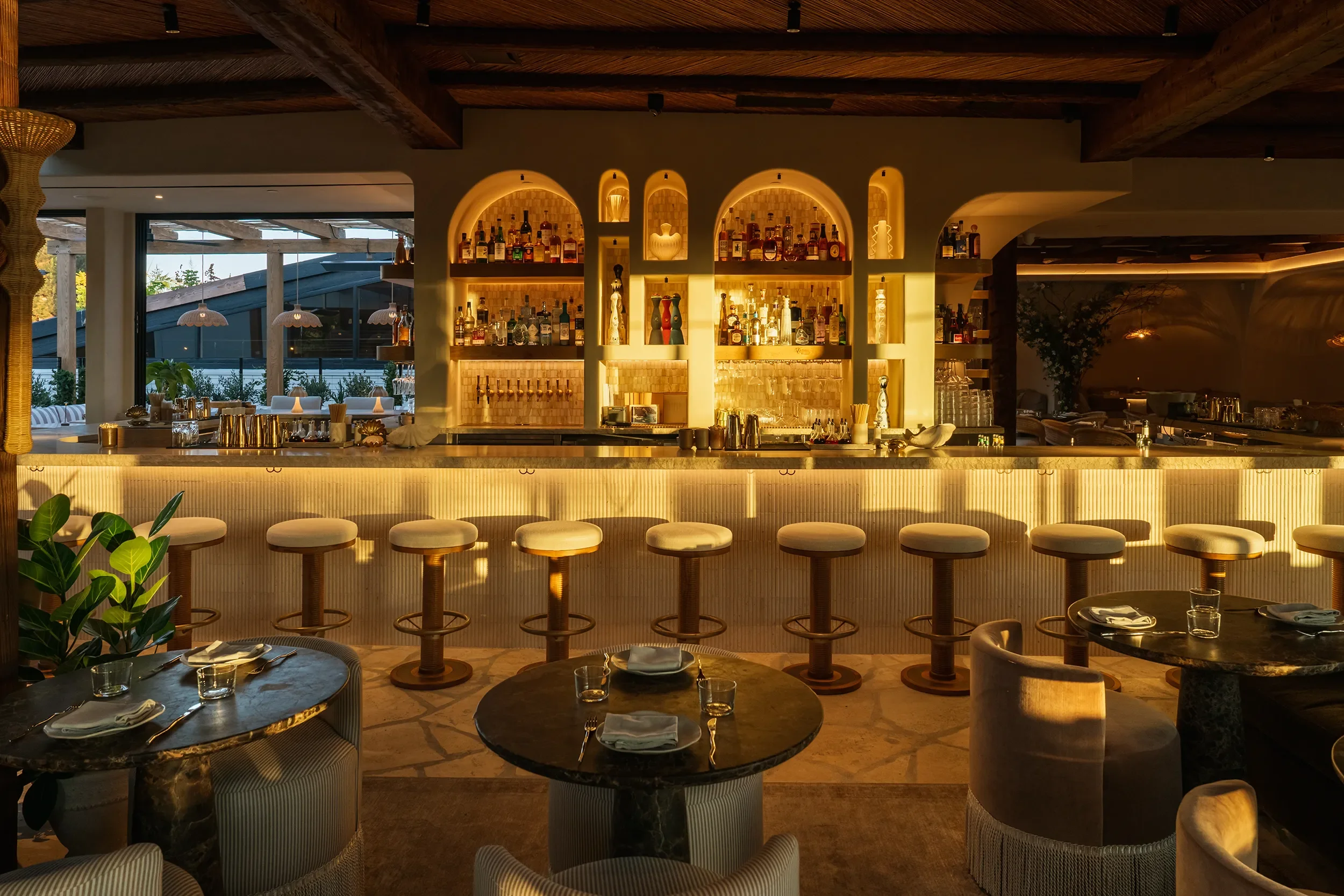 The 24-seat curved bar anchoring the main dining room at By The Sea, Coronado