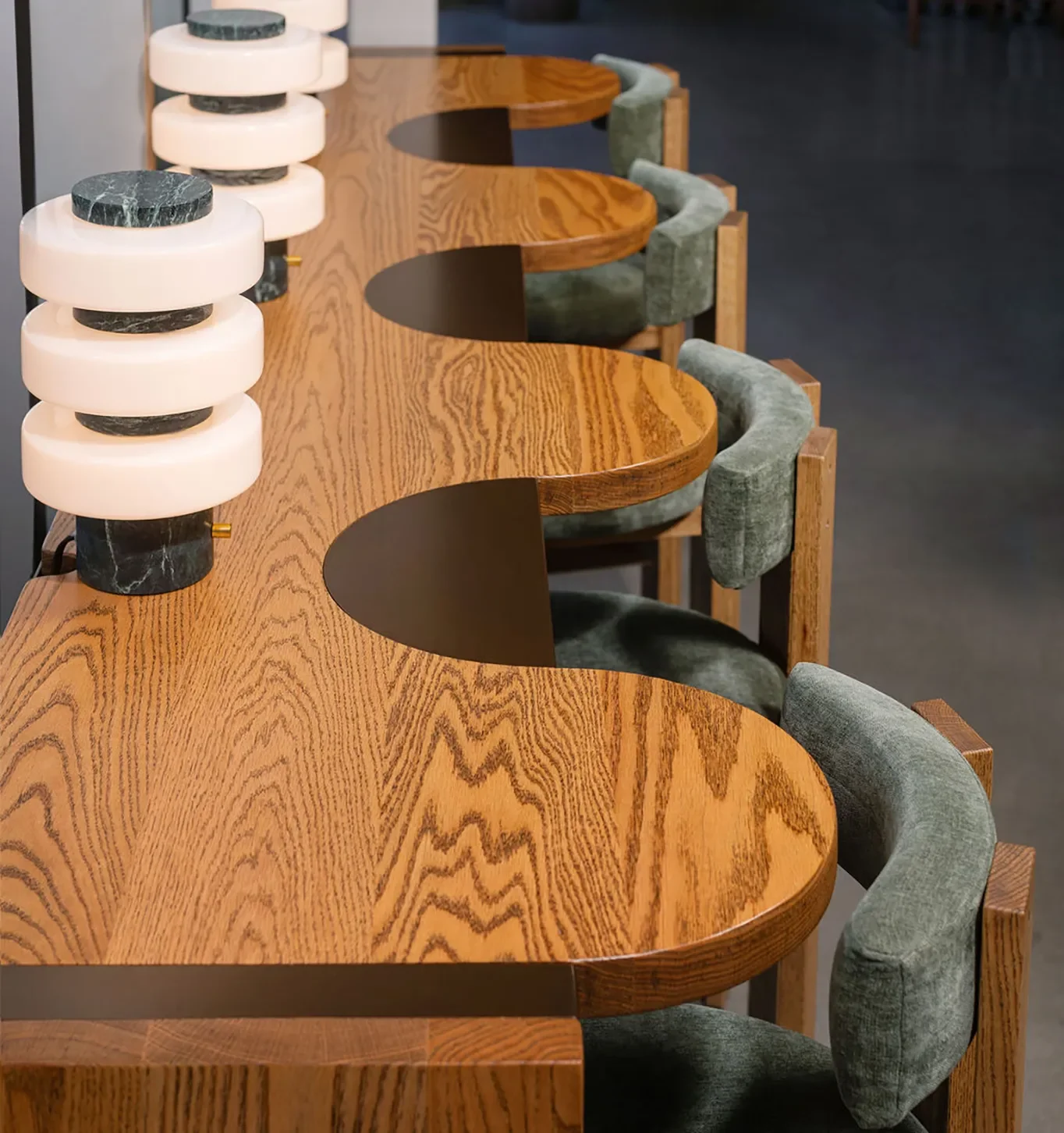 Hospitality interior at Base Pair Cafe with warm wood seating and sculptural table lamps.