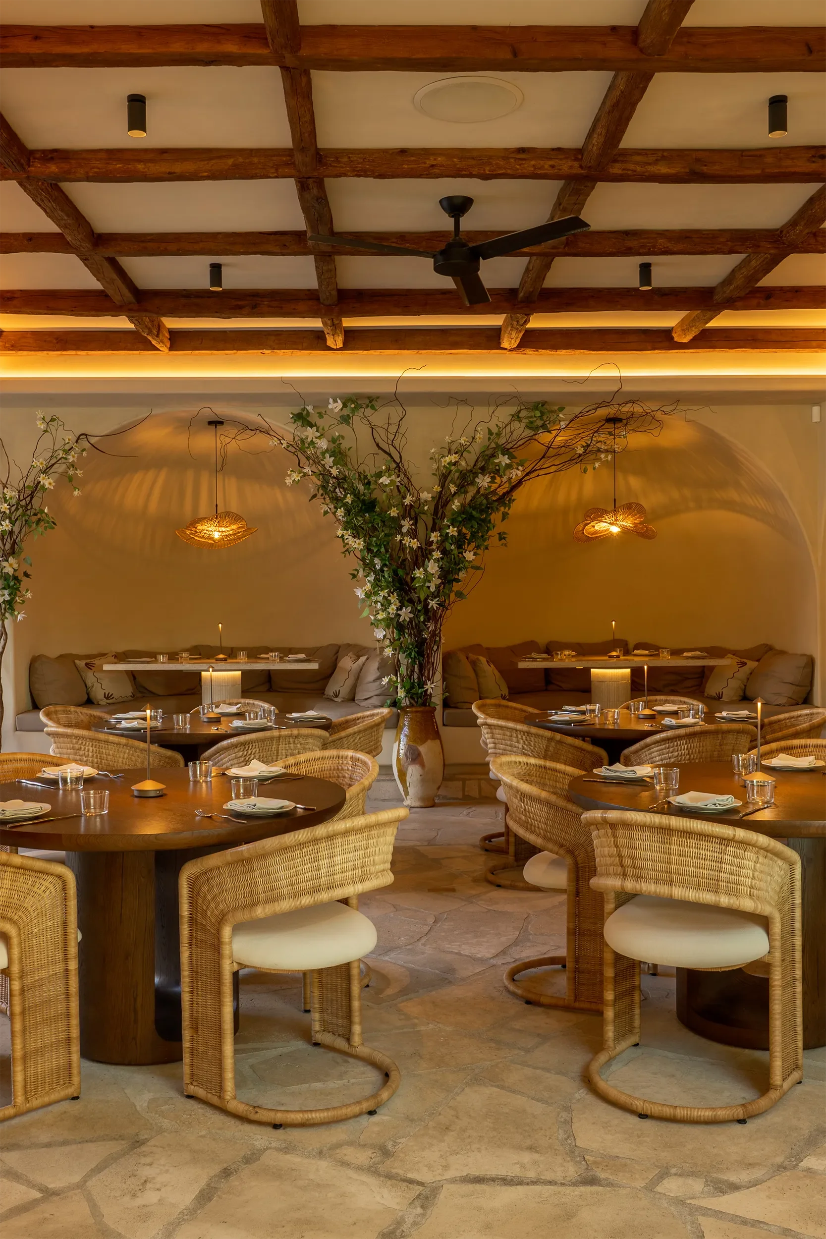 Coffered beam ceiling and cove lighting over rattan barrel chairs in the upper dining room at By The Sea