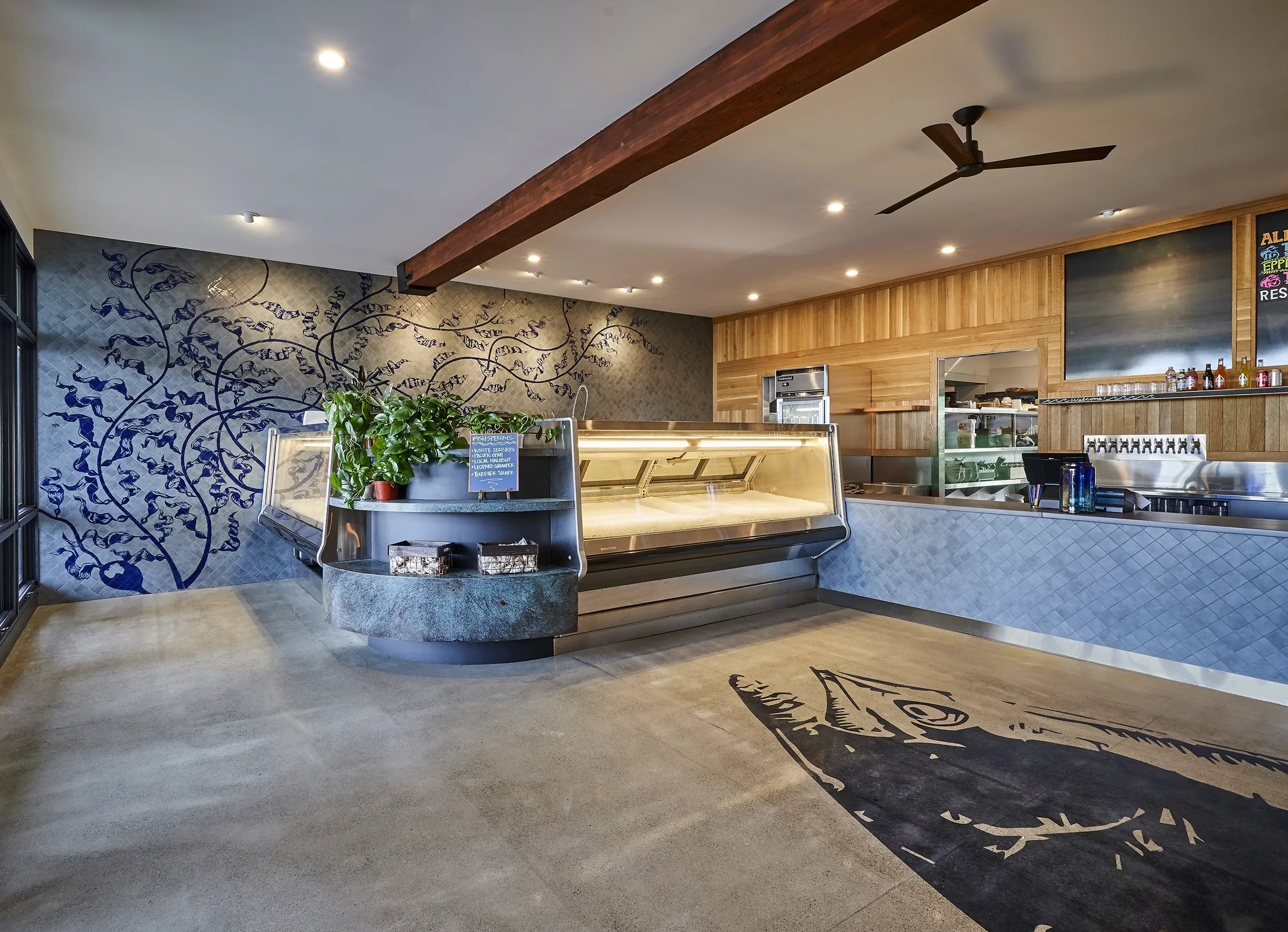 Concrete service counter and blue botanical mural at Blue Market in Ocean Beach