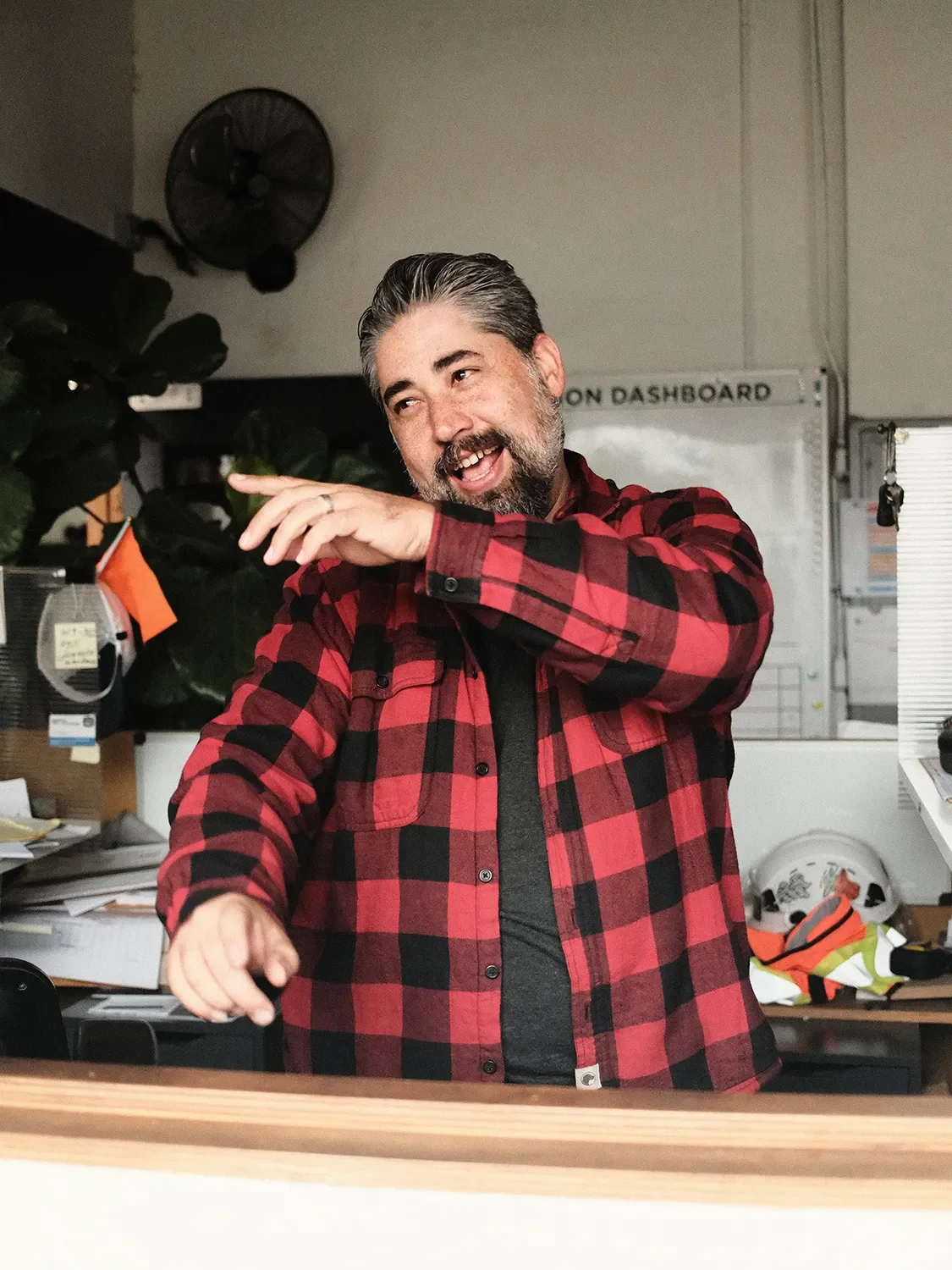 Ryan Carpenter gesturing and laughing during a conversation behind a wood worktop in the Tecture office