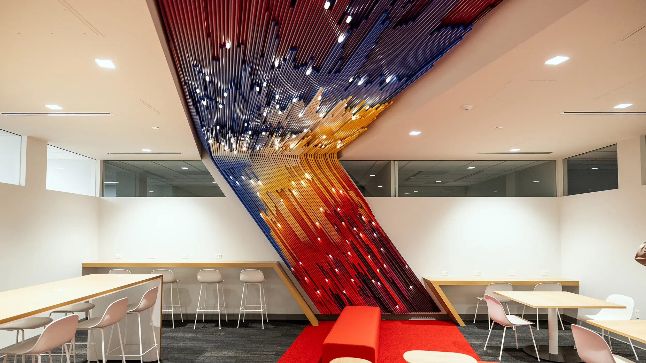 Colored PVC pipe art installation sweeping across the back wall and ceiling at UCSD