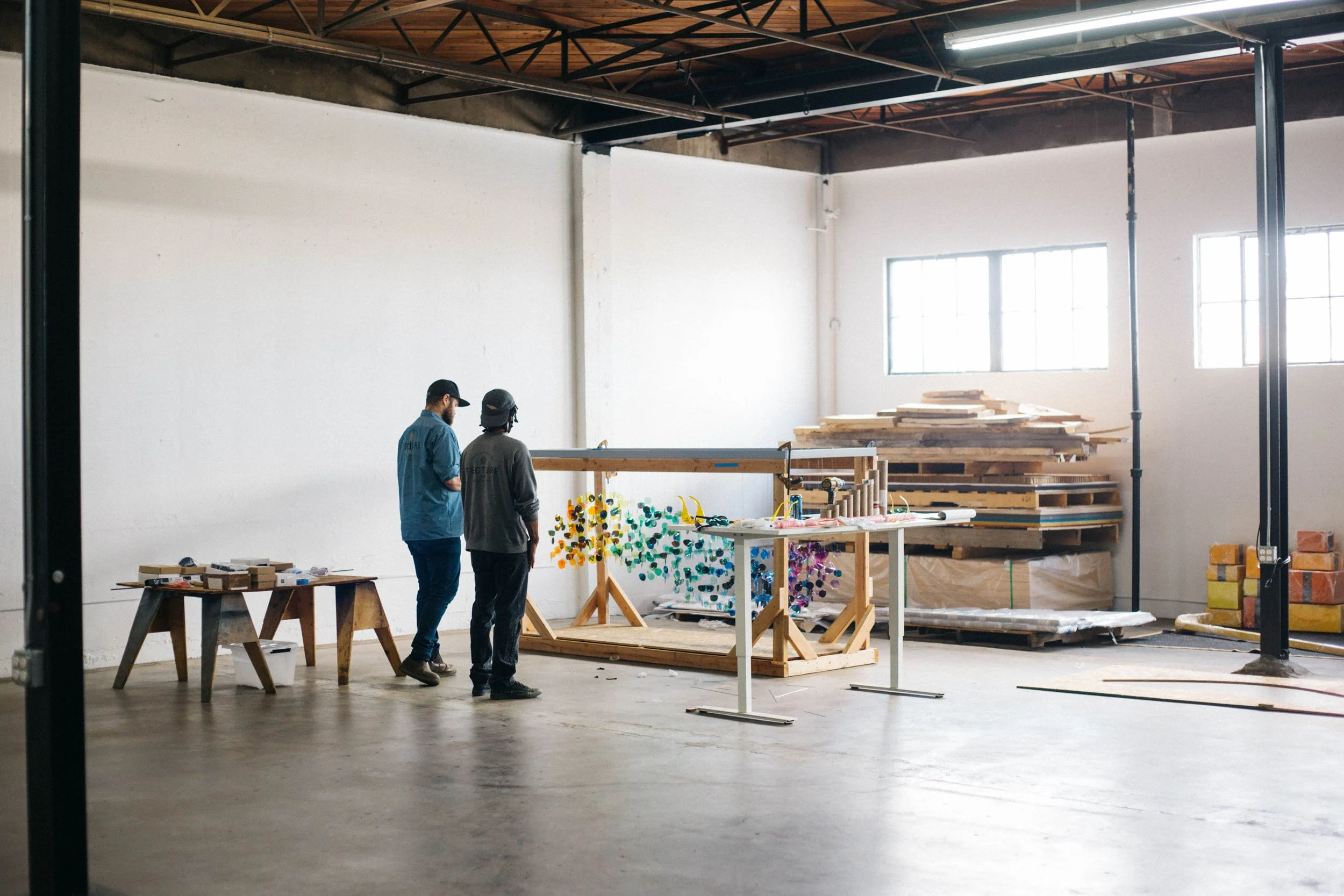 Tecture AF team members reviewing a custom art feature for a corporate EGD project, in the fabrication shop.