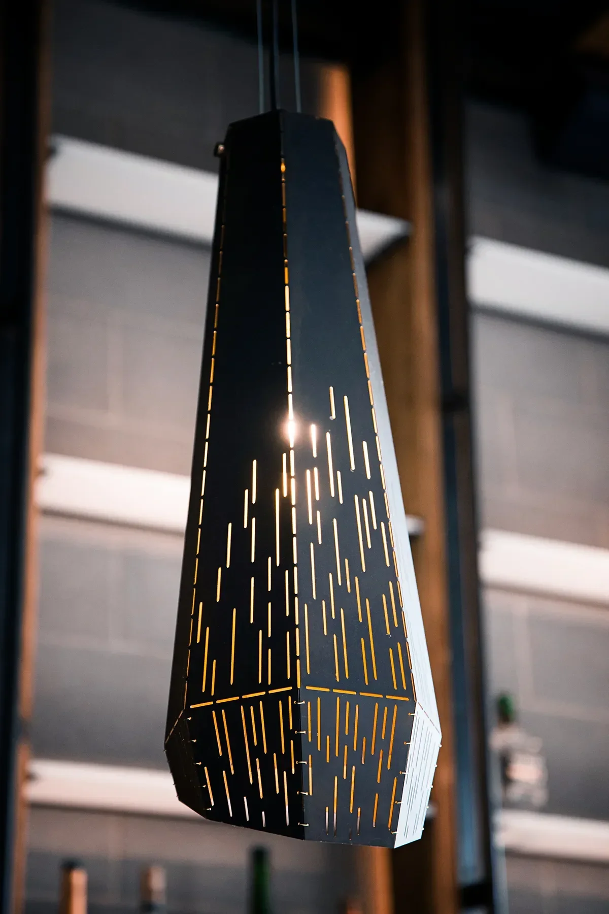 Perforated black metal cone pendant, a custom light fixture over the bar at The Patio in Mission Hills
