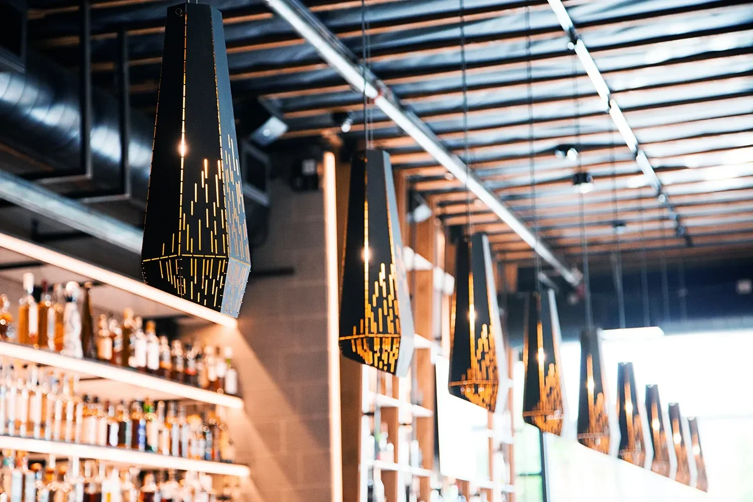 Row of perforated black cone pendants above the bar at The Patio in Mission Hills San Diego