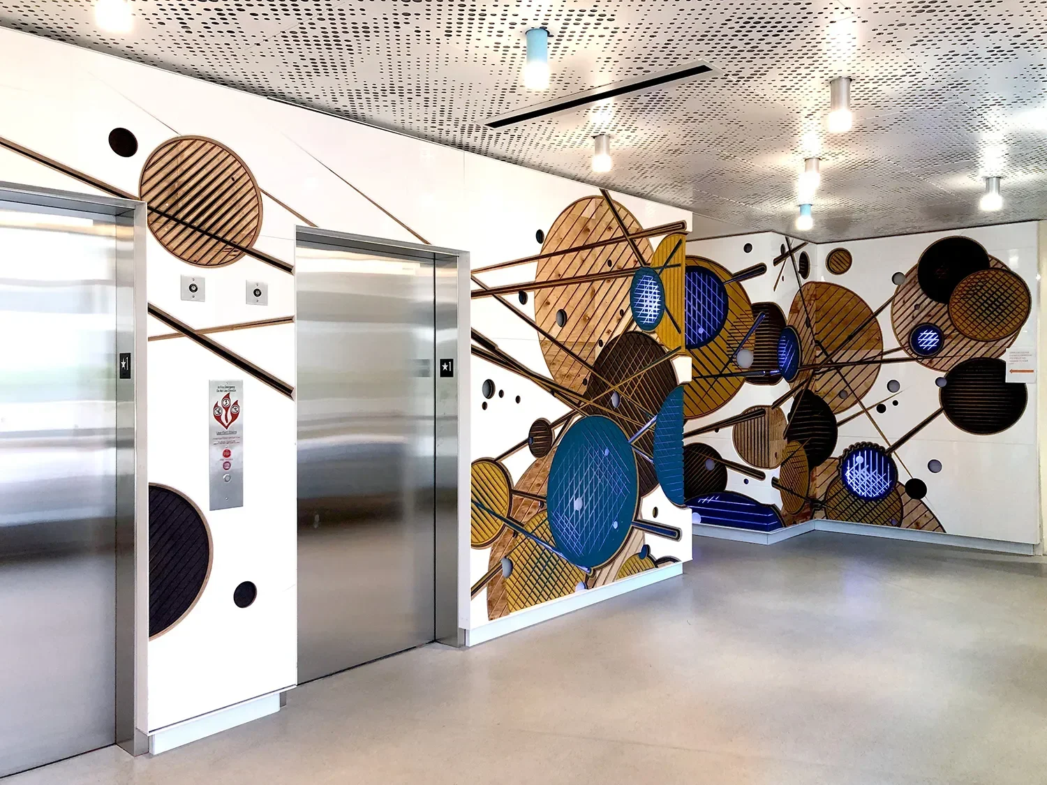 CNC carved wall cladding that exposes the stacked layers of MDF with integrated lighting in the entry space at UCSD