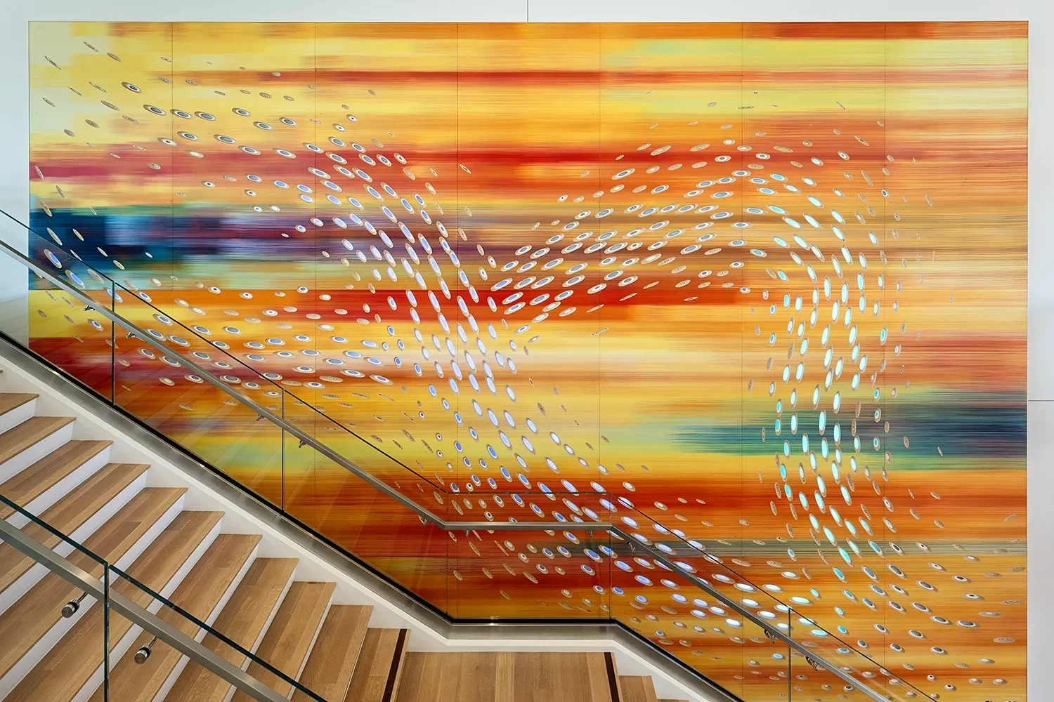 Hand painted wall art installation with CNC carved scoops and integrated lighting over a central staircase