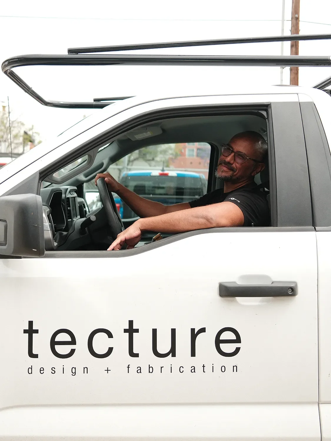 Andres Gaitan smiling from the driver's seat of a Tecture AF work truck