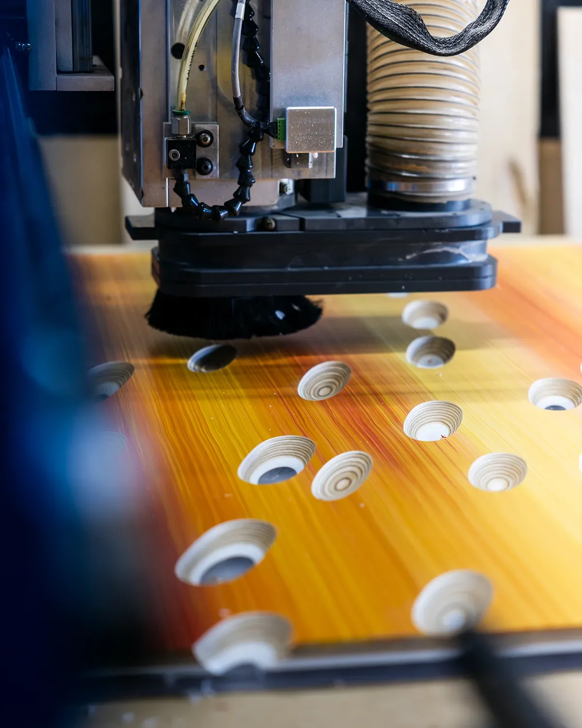 CNC router carving scoops into the sunset colored panels to expose the layers beneath the paint