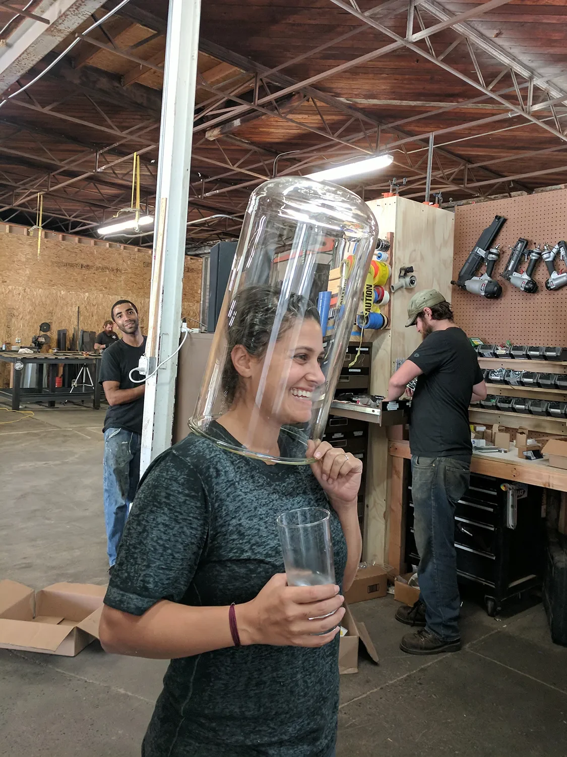 Sydney Preish playfully wearing a large glass cylinder over her head in the Tecture shop