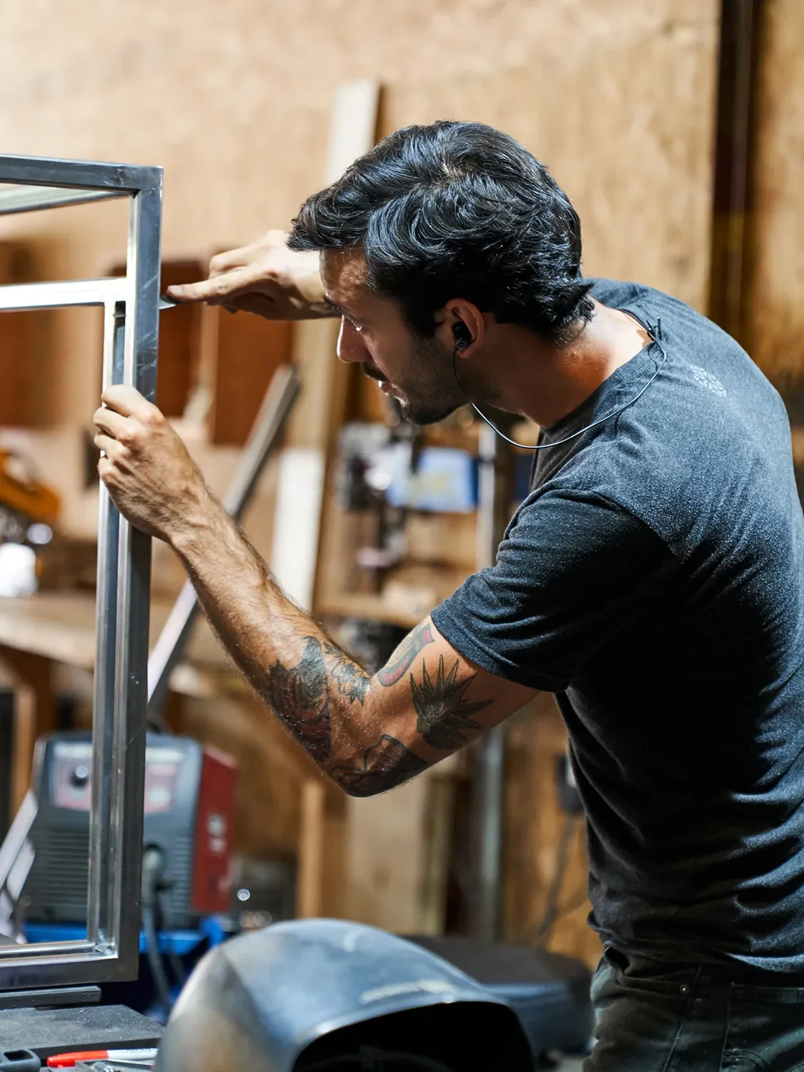 Andrés Viesca measuring a steel frame during metal fabrication in the Tecture shop