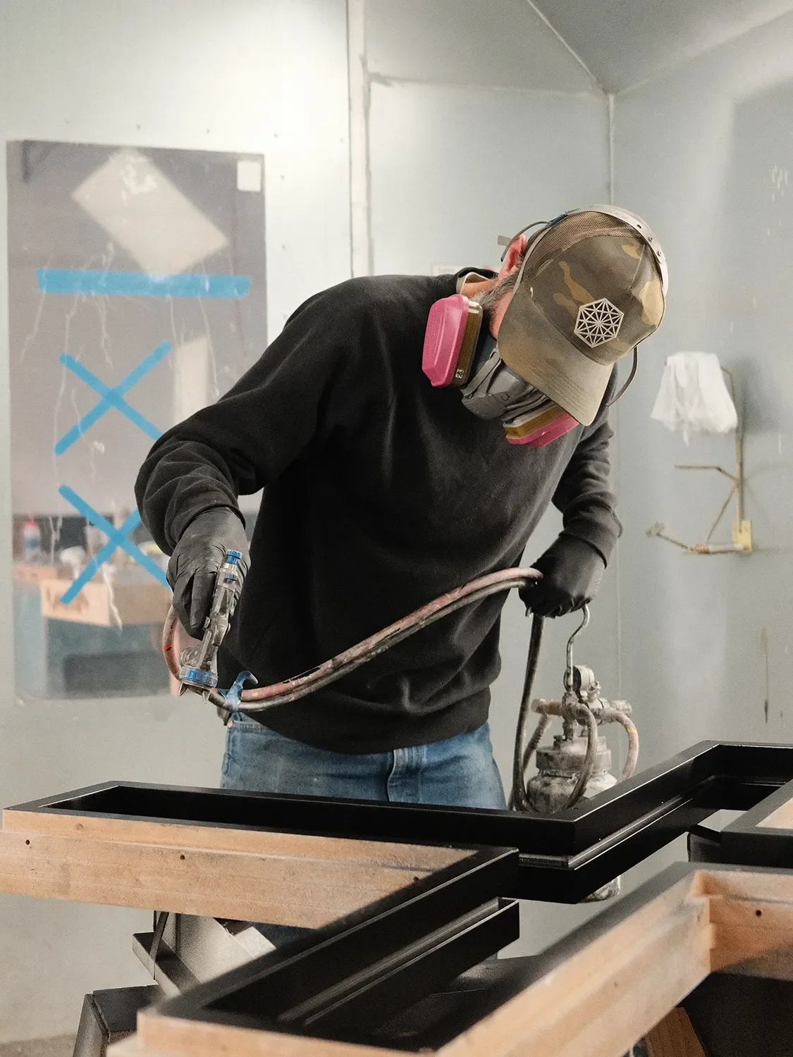 Justin Warchol using a spray gun to coat custom components in the Tecture finishing booth