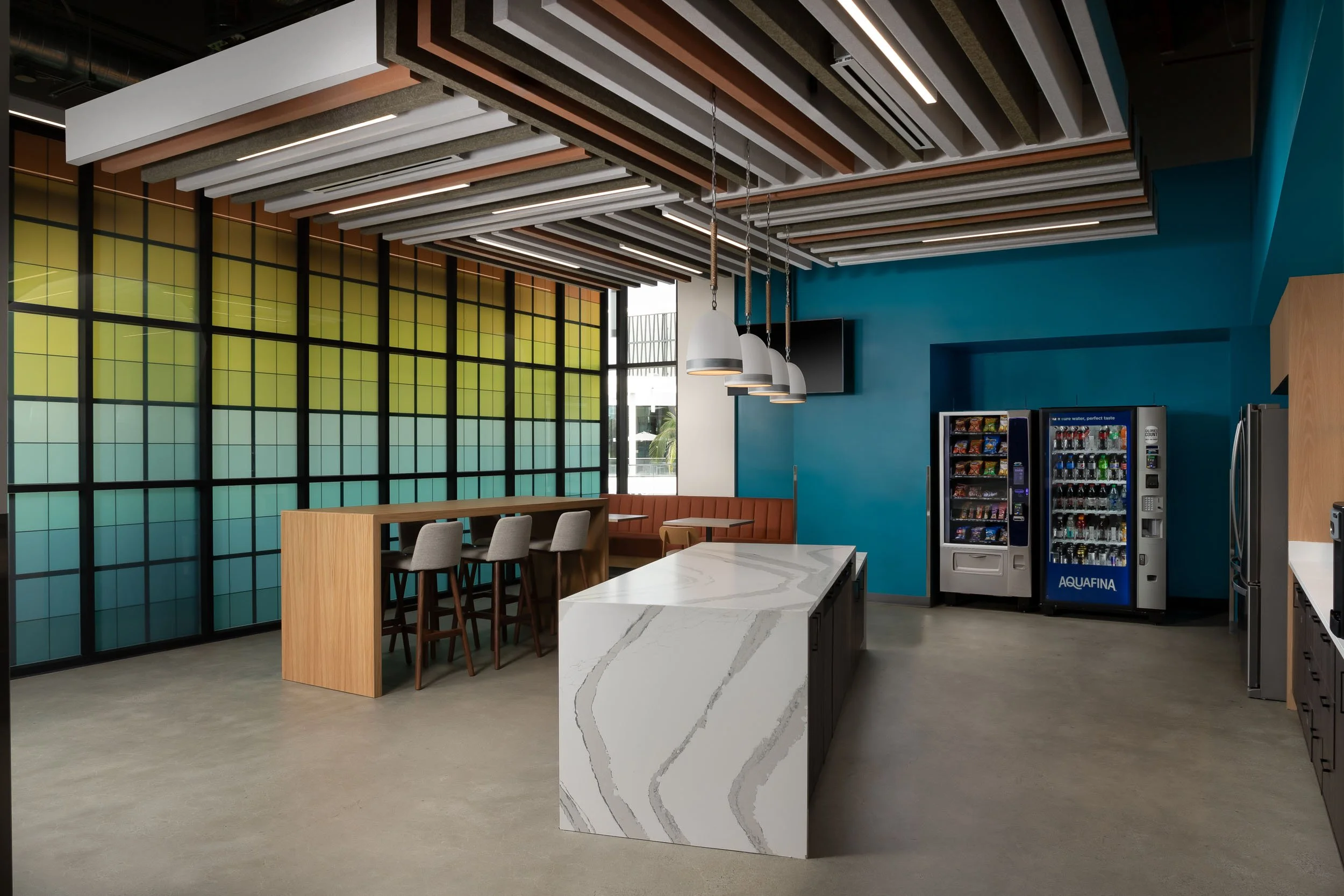 Corporate communal office space with a custom teal wall, a gradient colored feature wall, and a custom felt ceiling feature.
