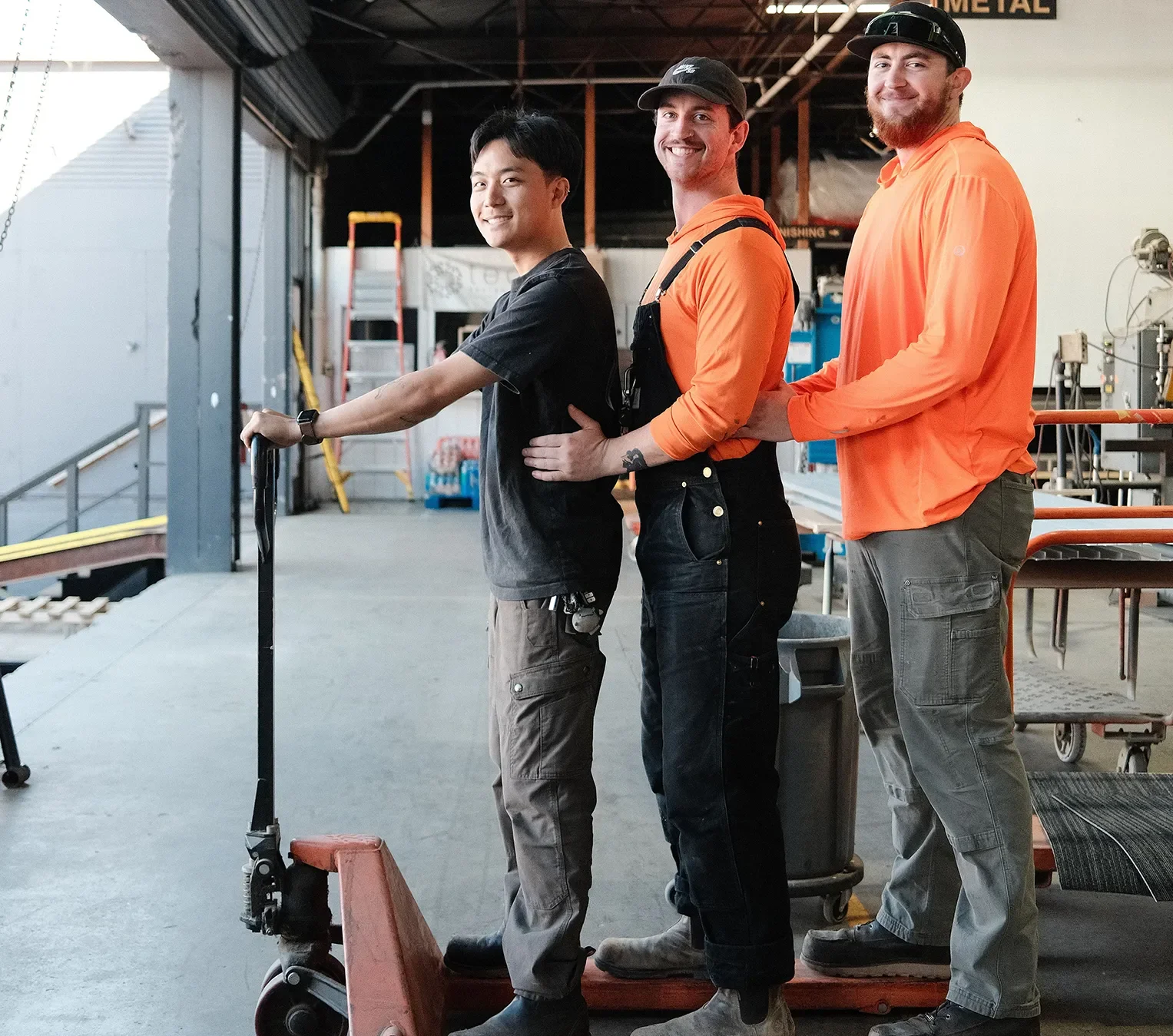 Tecture AF crew in orange shirt having fun and standing in a silly pose in the San Diego shop.