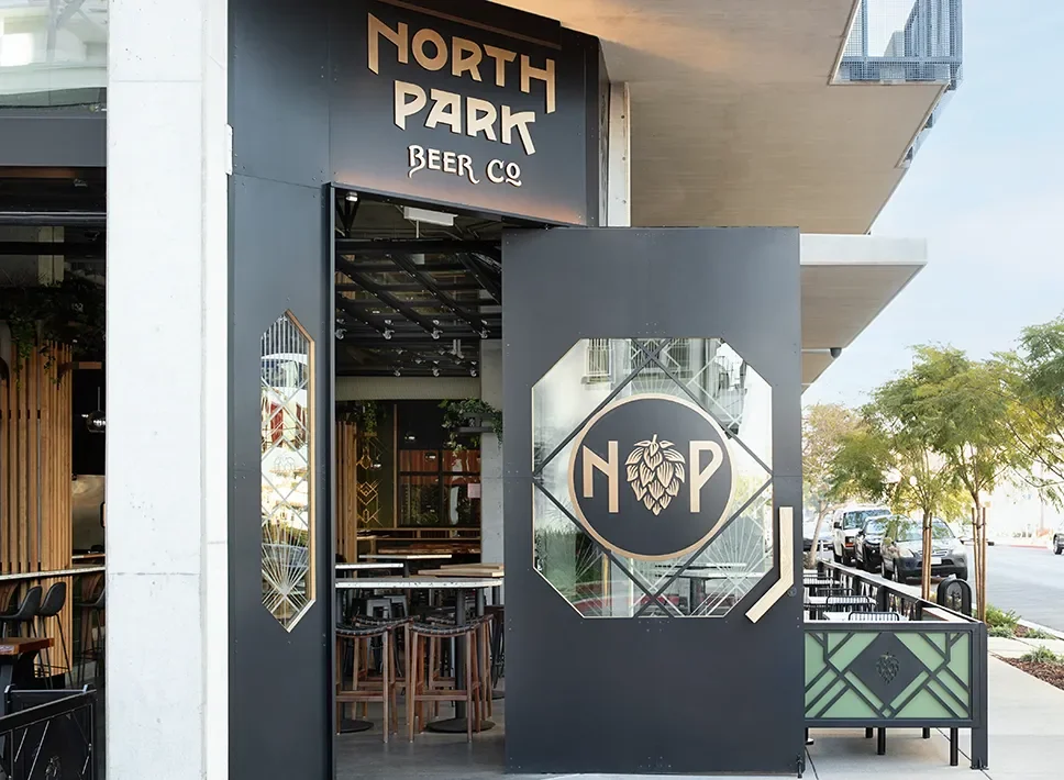 Custom metal entry door with a diamond hop emblem at North Park Beer Co in Bankers Hill