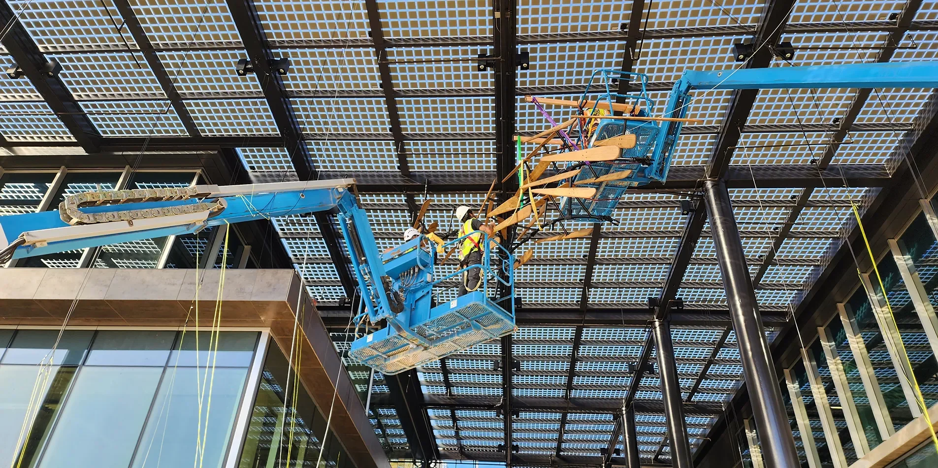 Tecture AF installation team on a boom lift installing and assembling the migration sculpture art installation