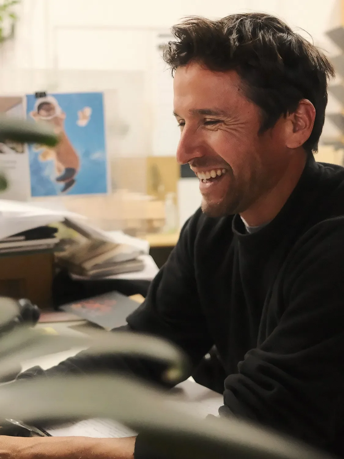 David Michael Ortiz laughing at his desk in the Tecture Design Studio