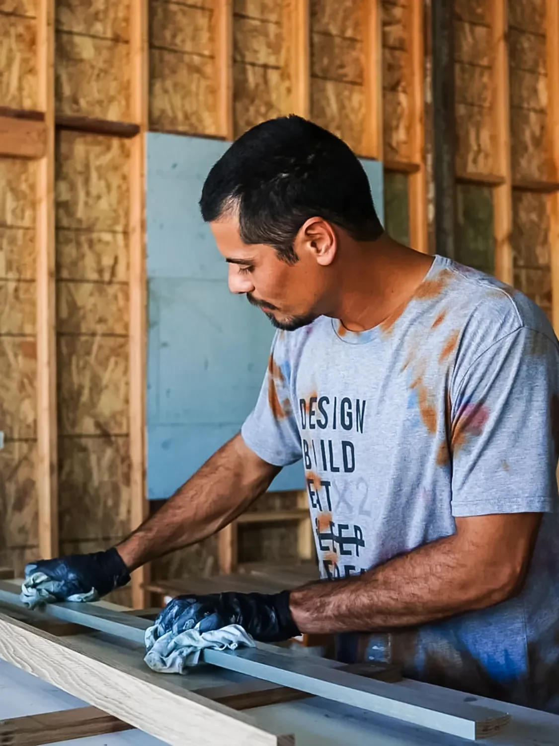 Alex Gaerlan wiping down long rectangular components with a finisher in the Tecture AF shop