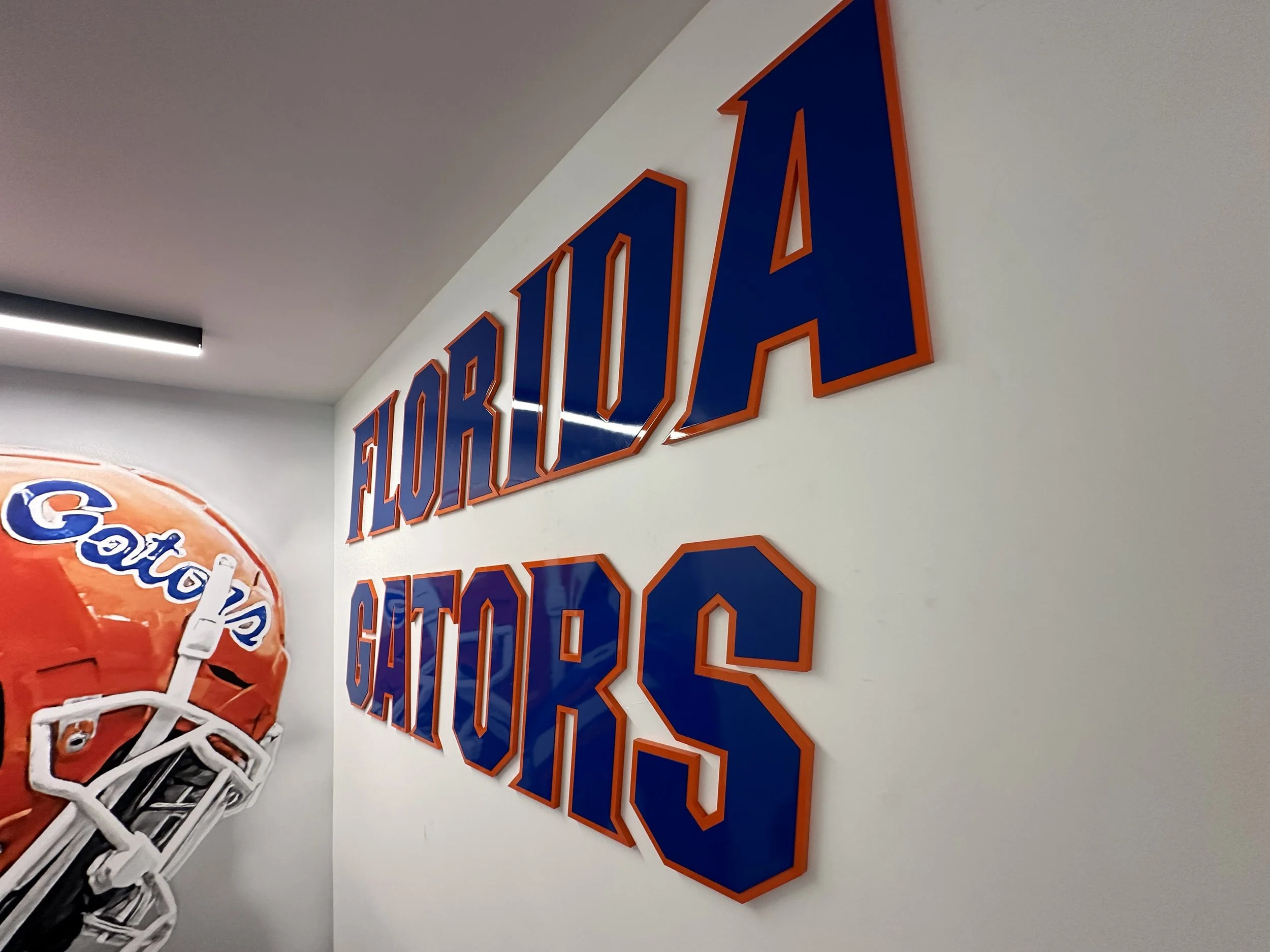 Florida Gators sign and helmet displayed on a wall