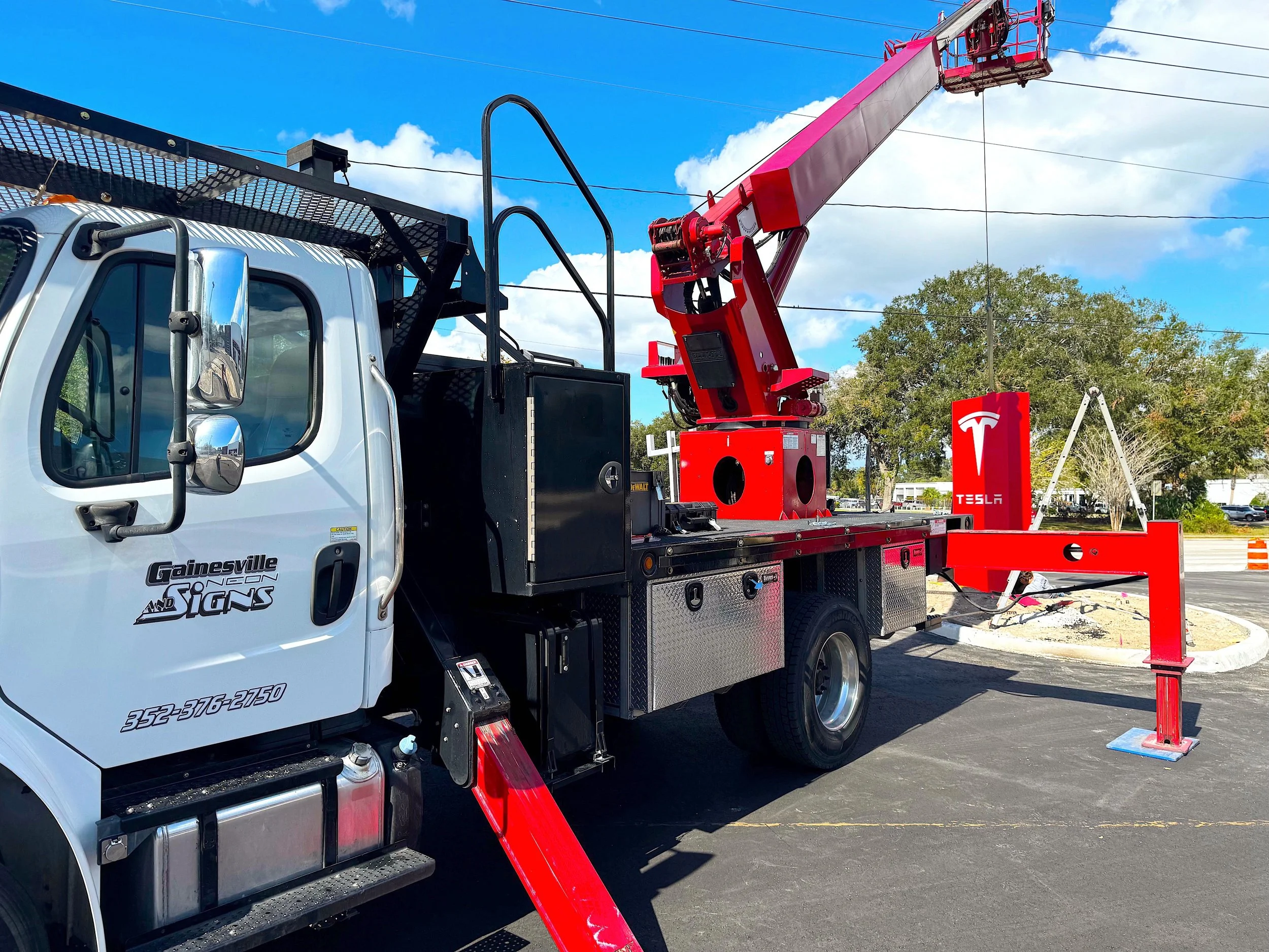 Truck positioned to install a Tesla sign