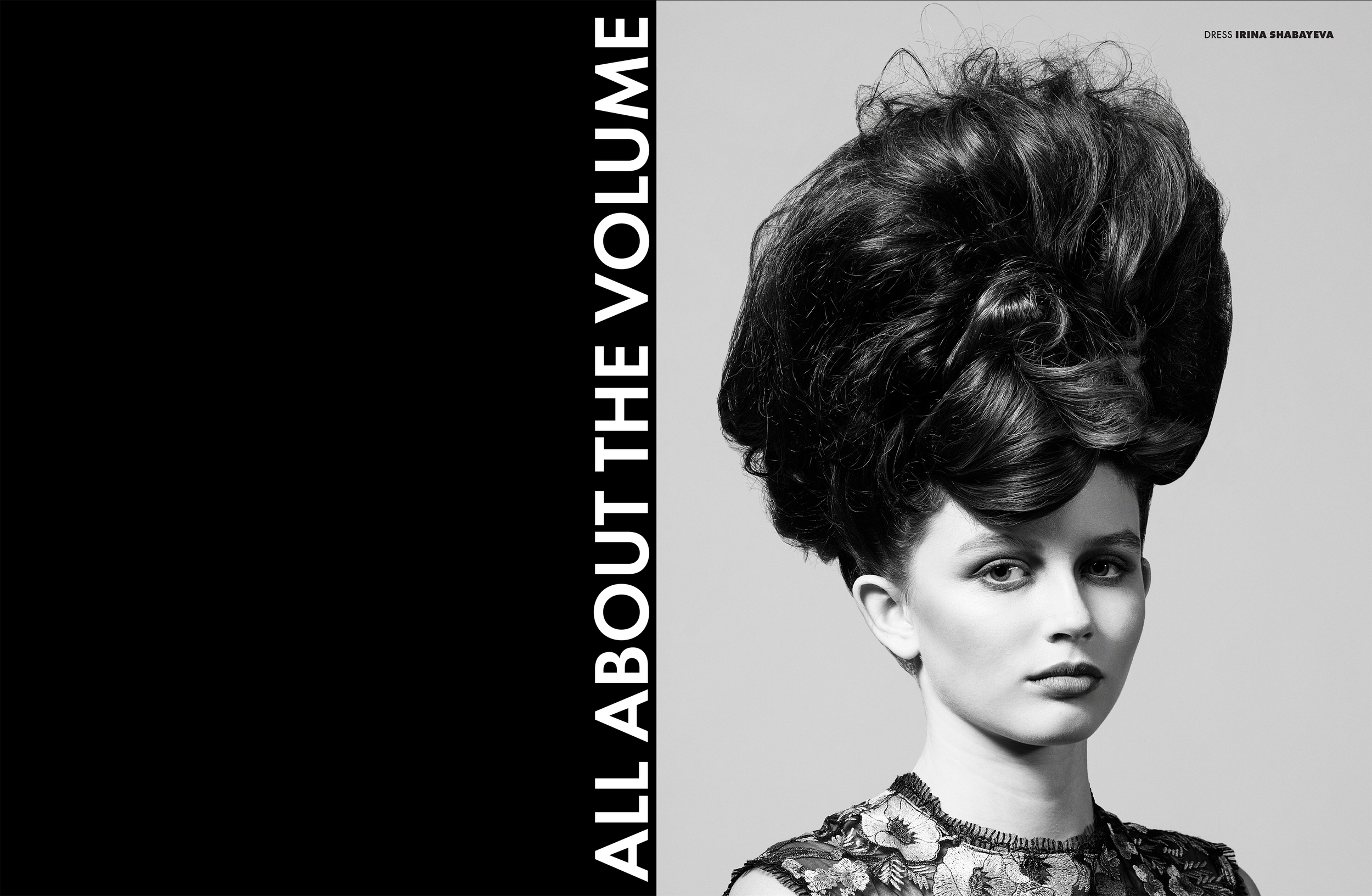 Black and white magazine cover featuring a woman with an elaborate updo hairstyle and a floral lace top. The left side has a black background with white text reading "ALL ABOUT THE VOLUME." The top right corner has smaller text identifying the dress as Irina Shabayaeva.