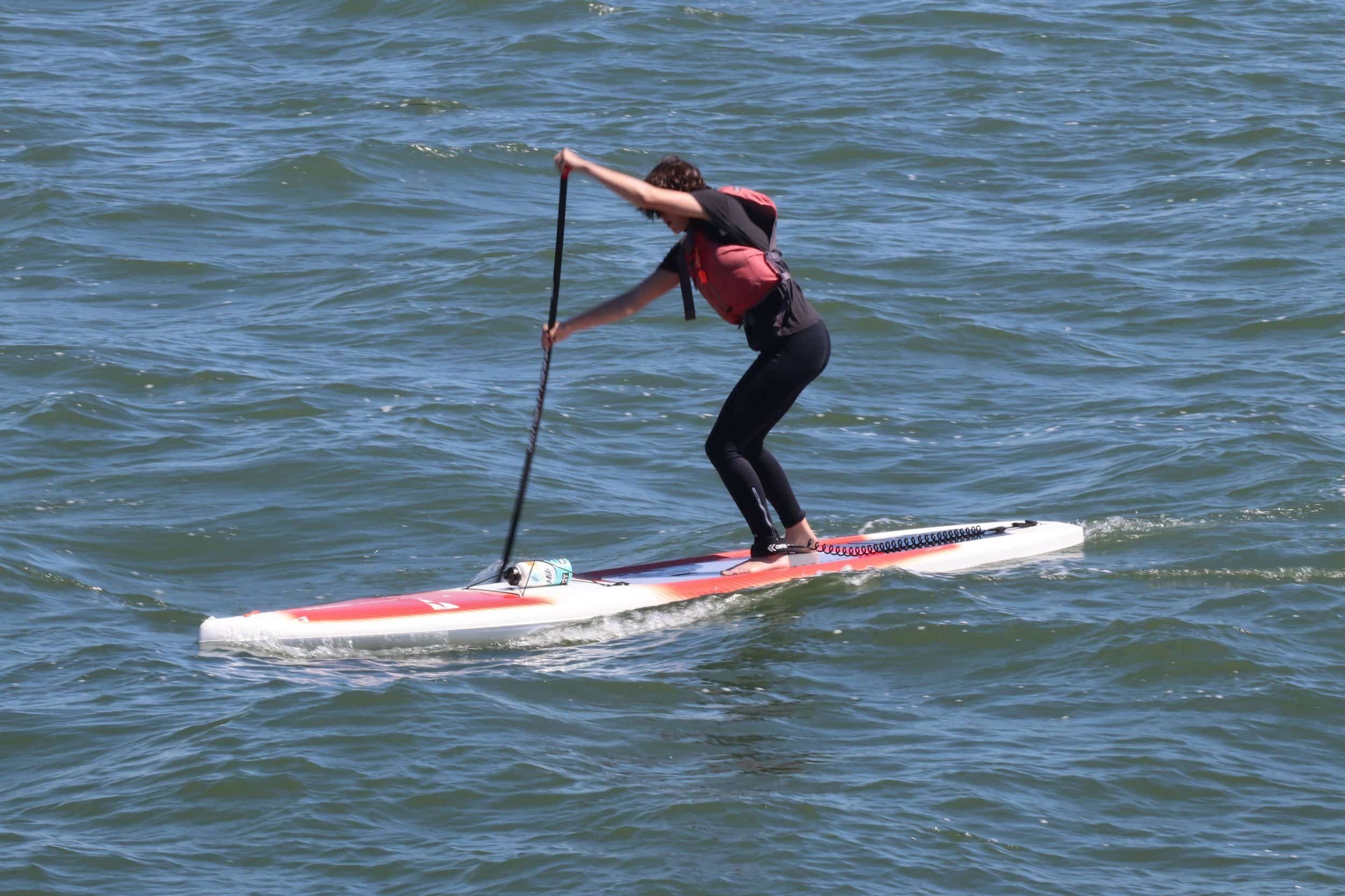 A teen standing on a paddleboard on the San Francisco Bay near Alameda.